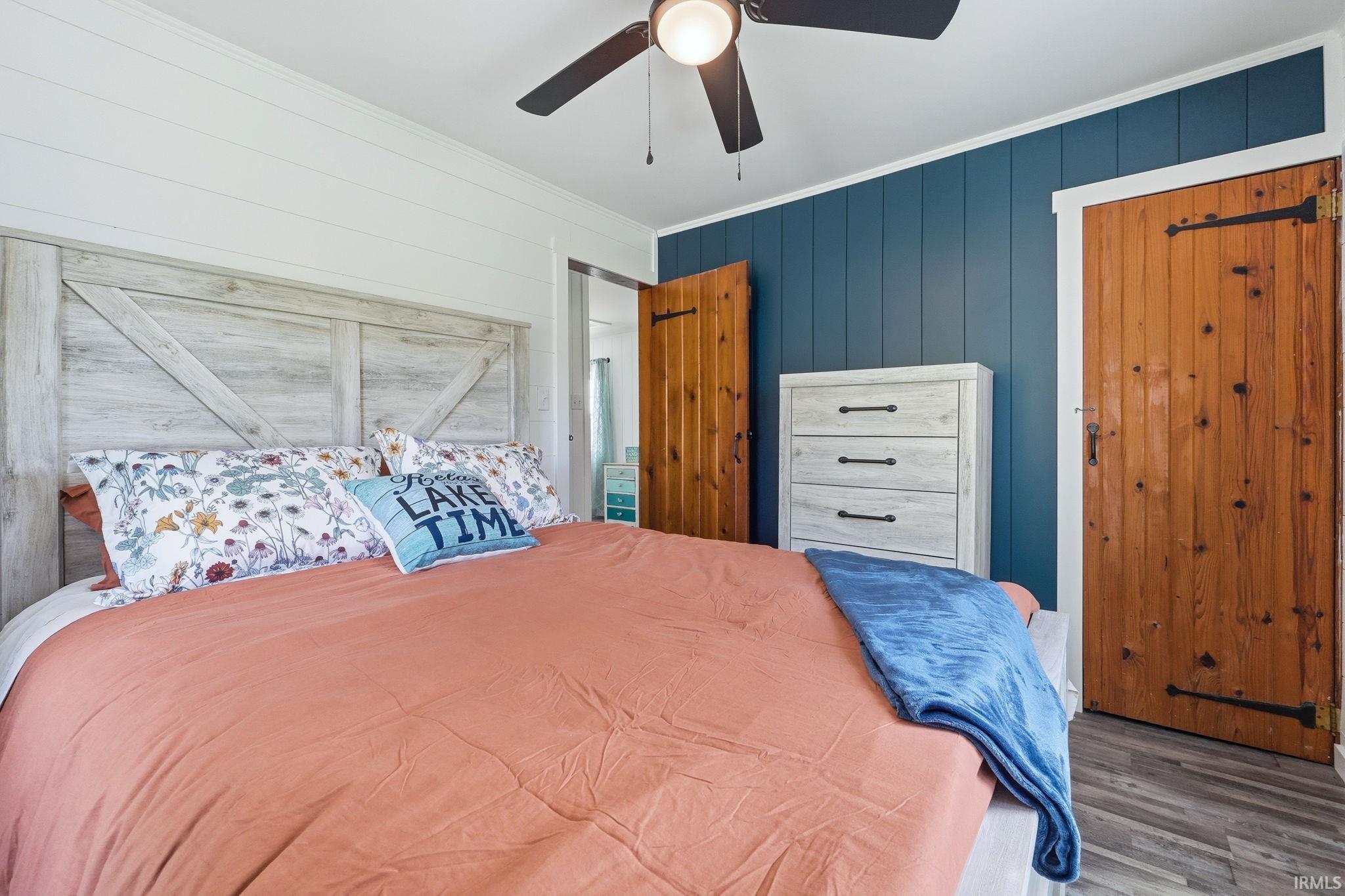 Wood-look flooring complements the accent wall featuring vertical paneling
