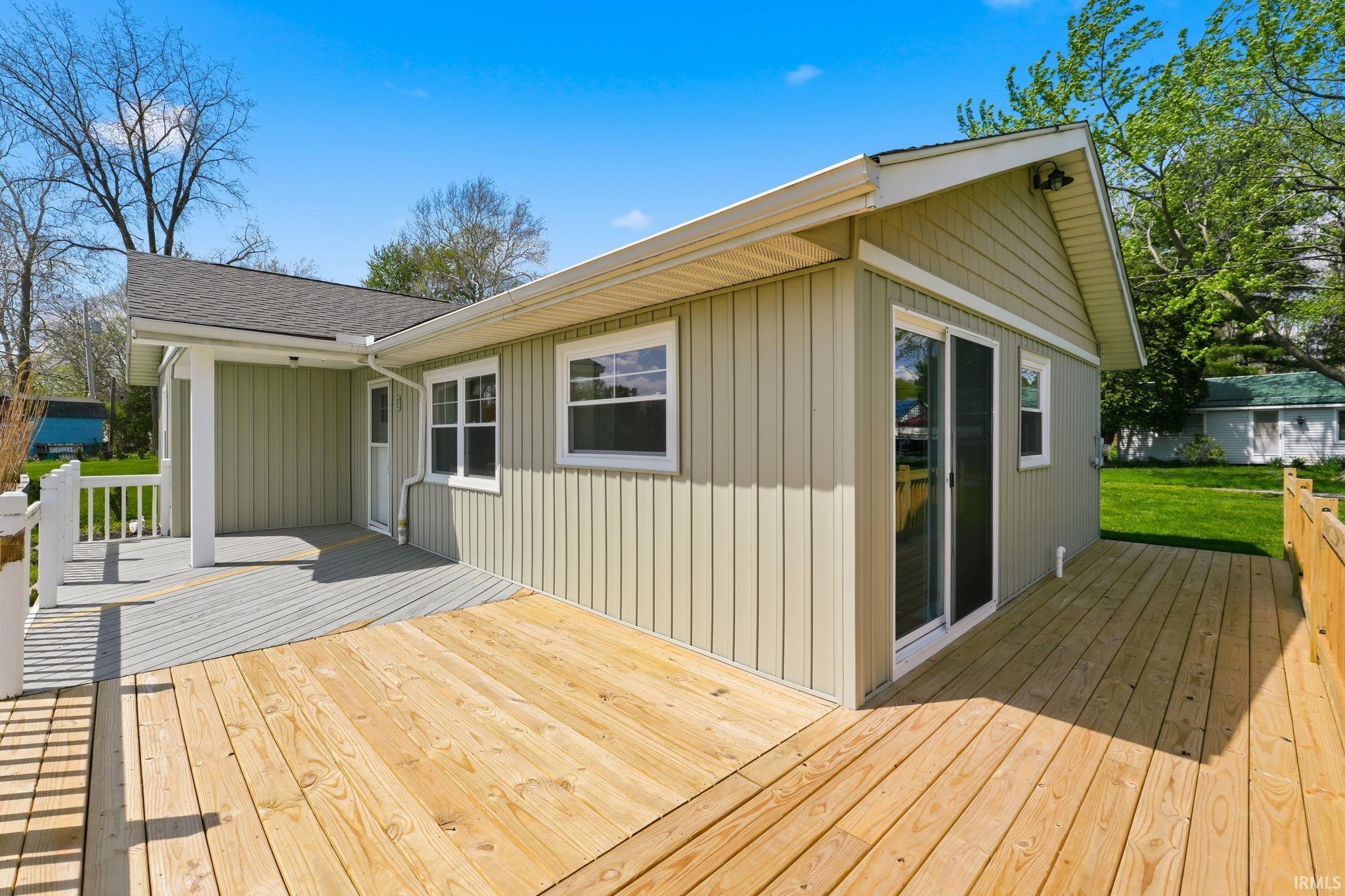Expansive wood-finish deck with a partial covered porch