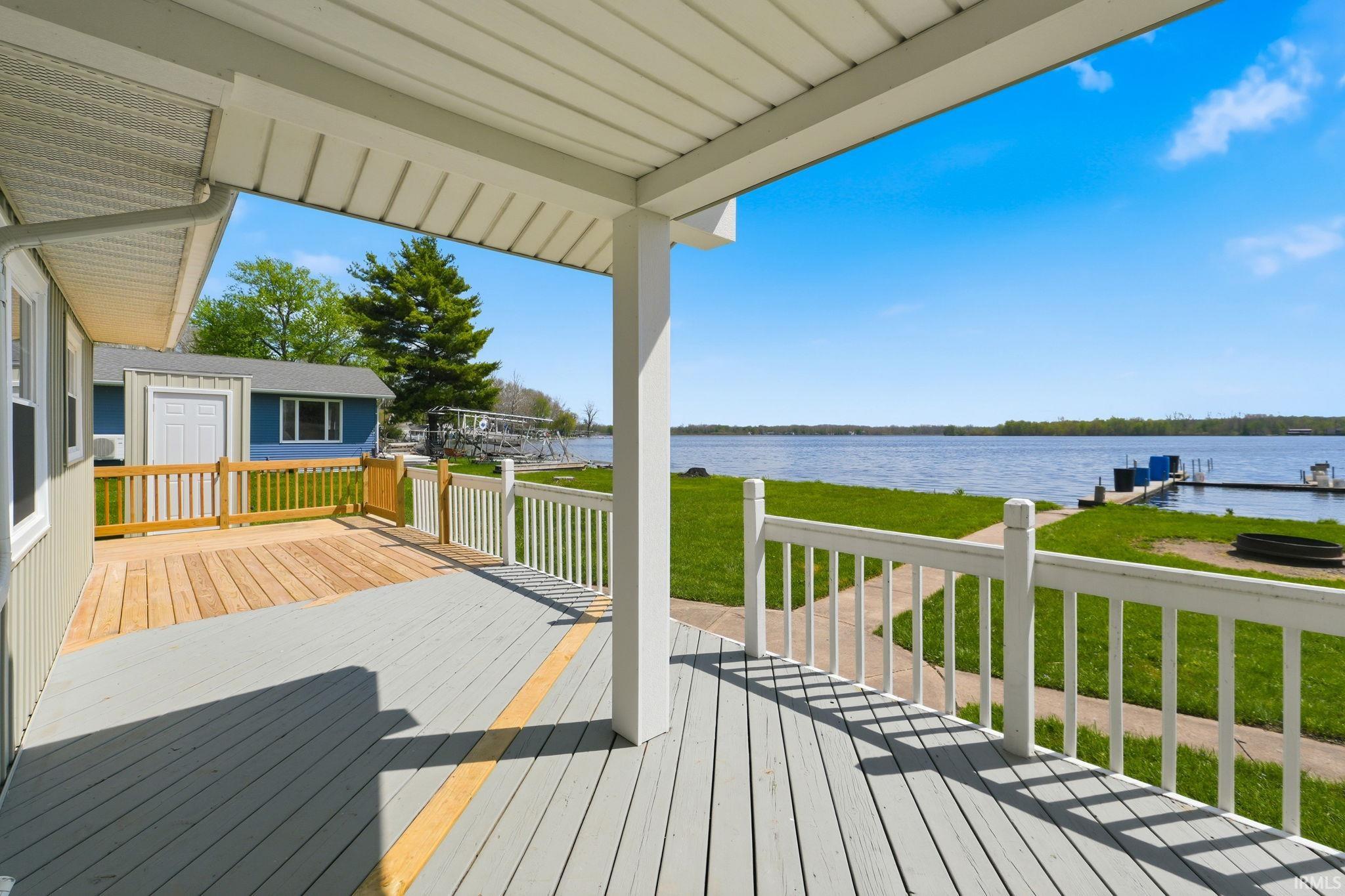 Expansive covered deck with light gray and natural wood-tone flooring