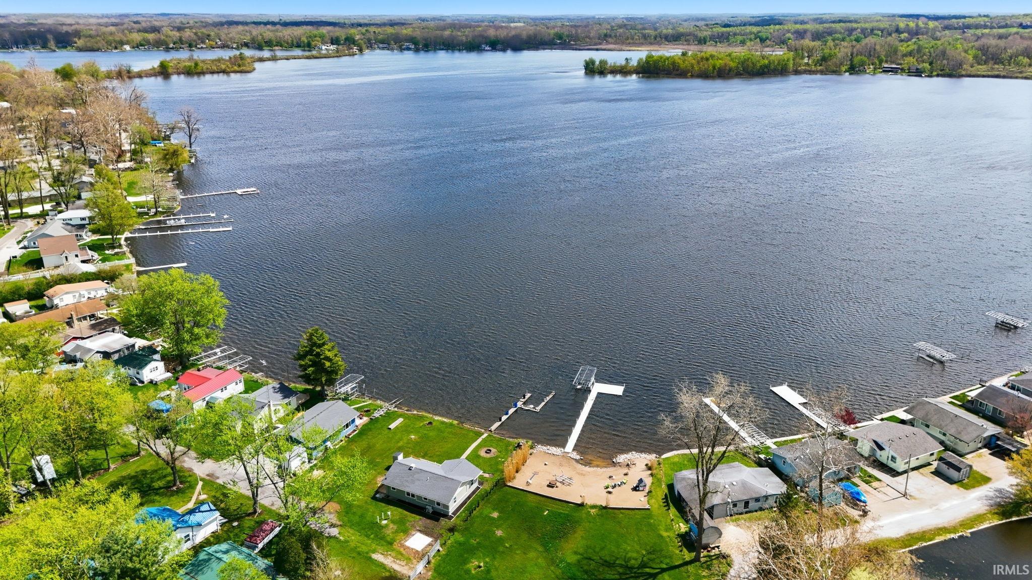 Lakeside property featuring direct water access, private boat dock, and sandy shoreline