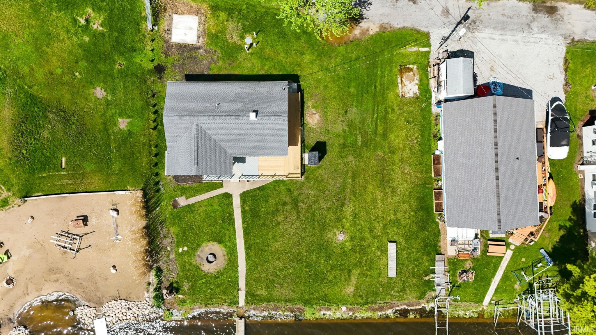 Waterfront property featuring a sandy area, a stone retaining wall, and two docks