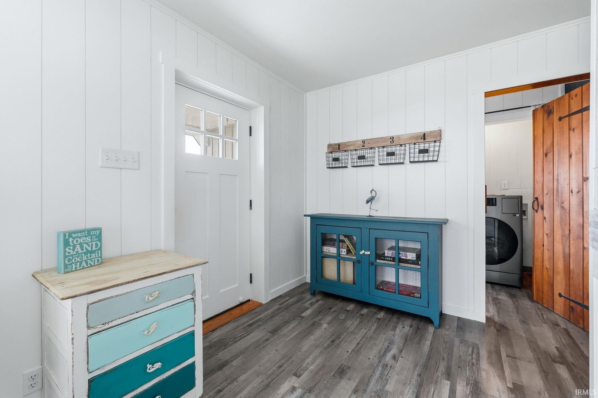 Entryway featuring white vertical plank walls and wood-finish flooring