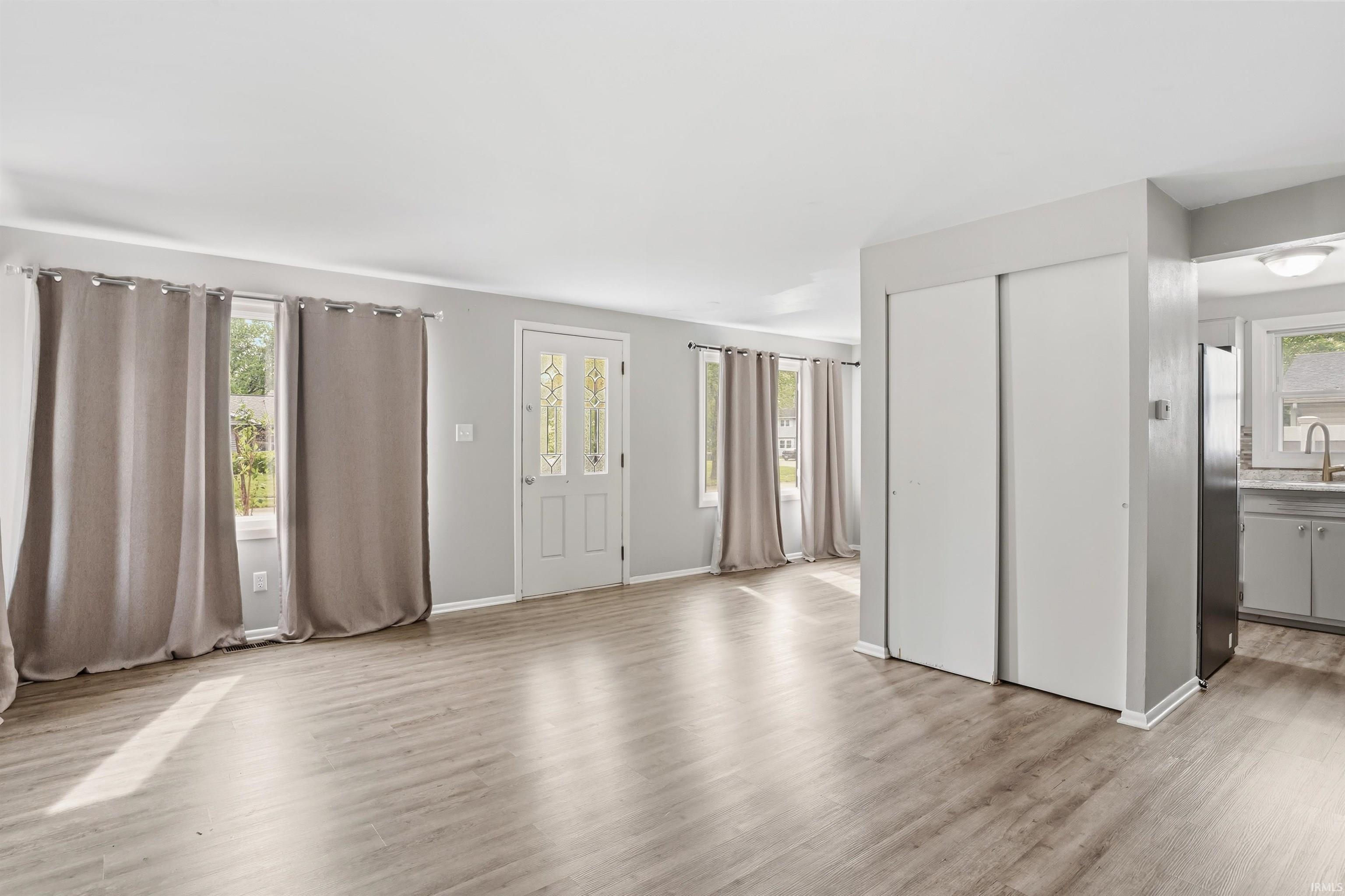 Open concept living area featuring wood-finish flooring