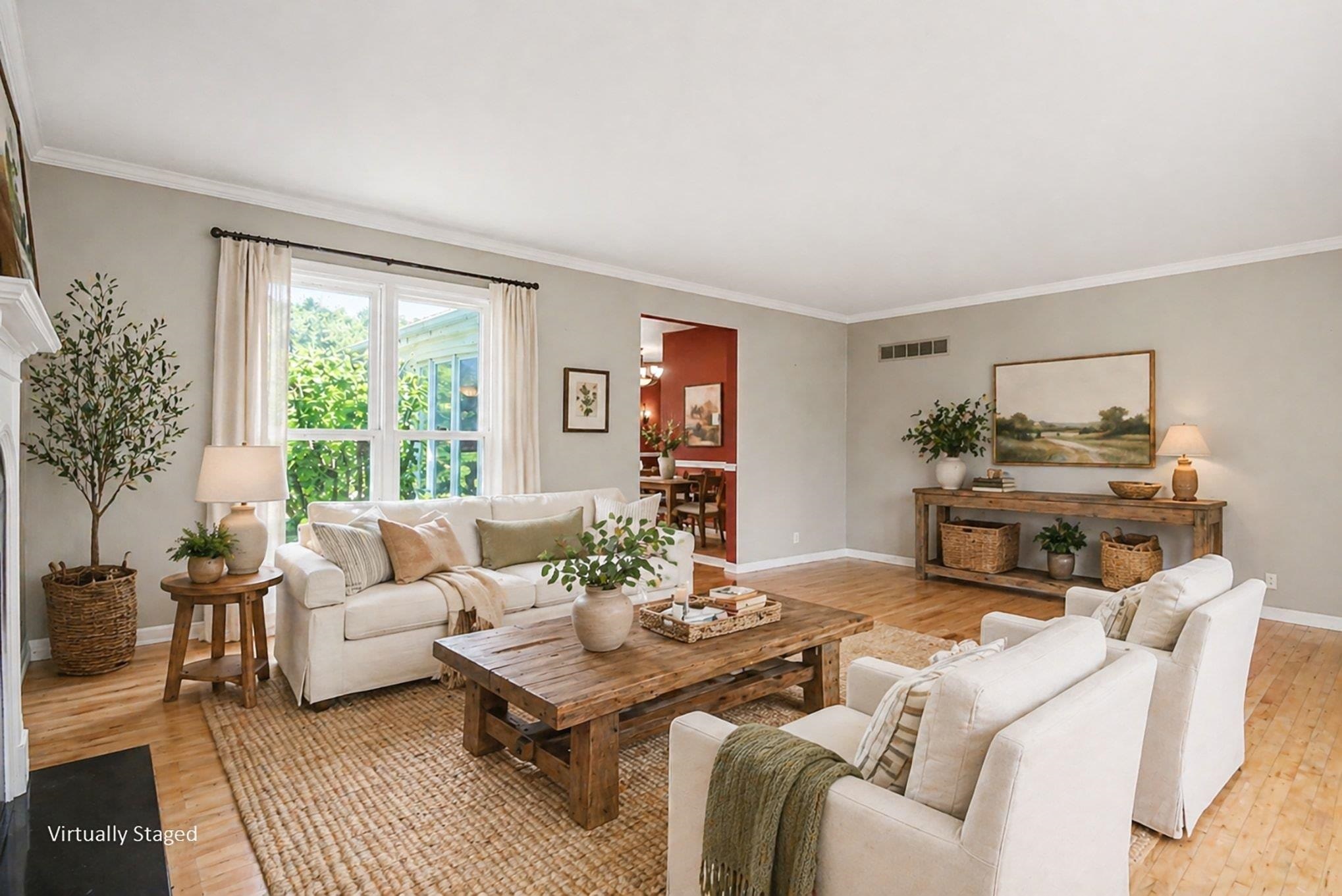 Hardwood flooring throughout this living area with white crown molding and baseboards