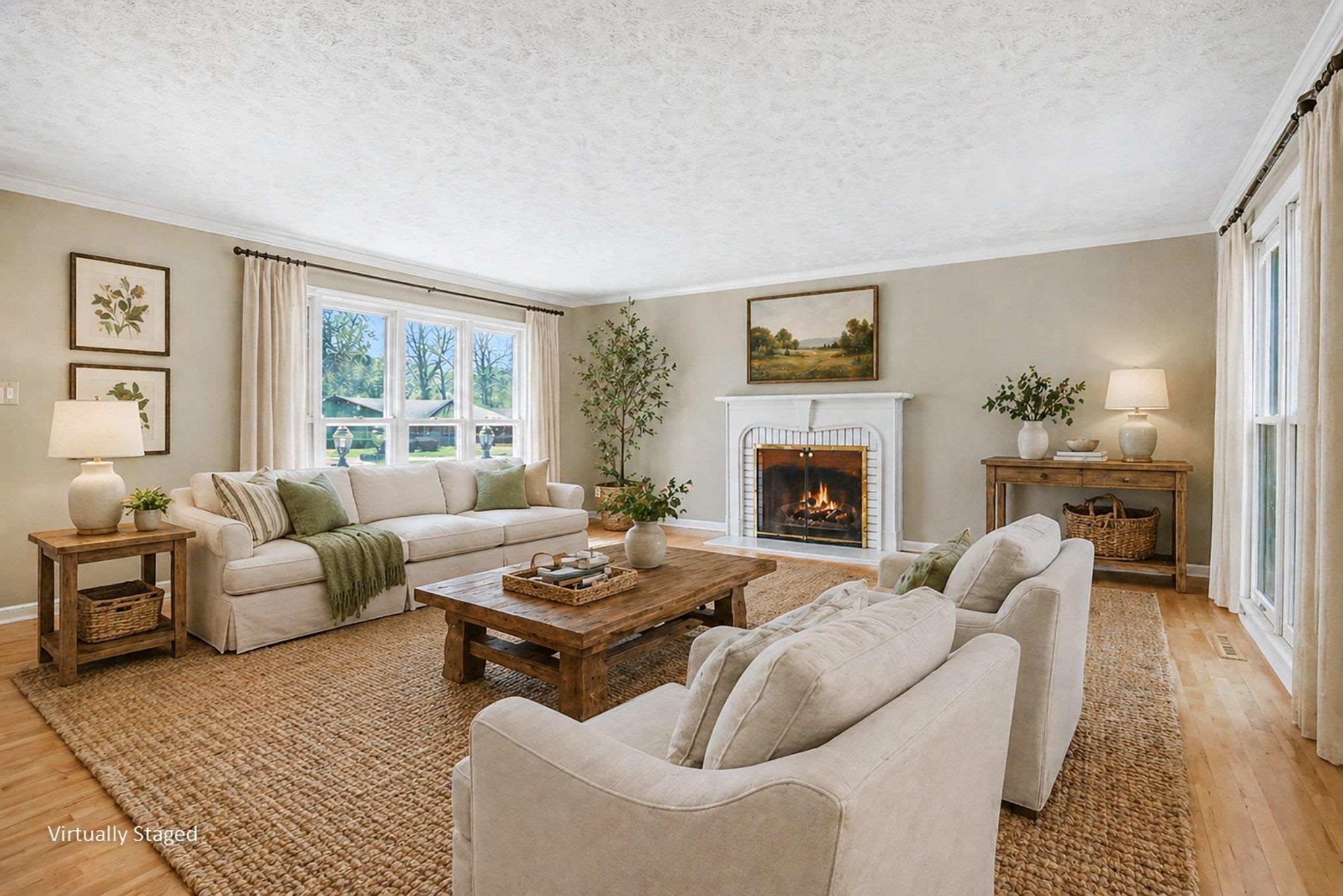 Spacious living area featuring wood-finish flooring, a traditional fireplace with a white mantel, and large windows