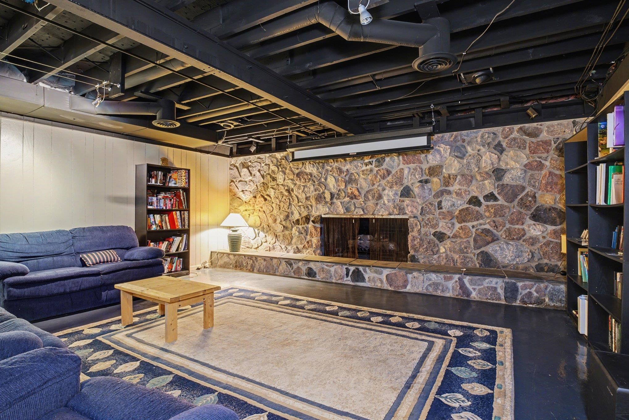 Stone-clad fireplace with hearth and integrated shelving