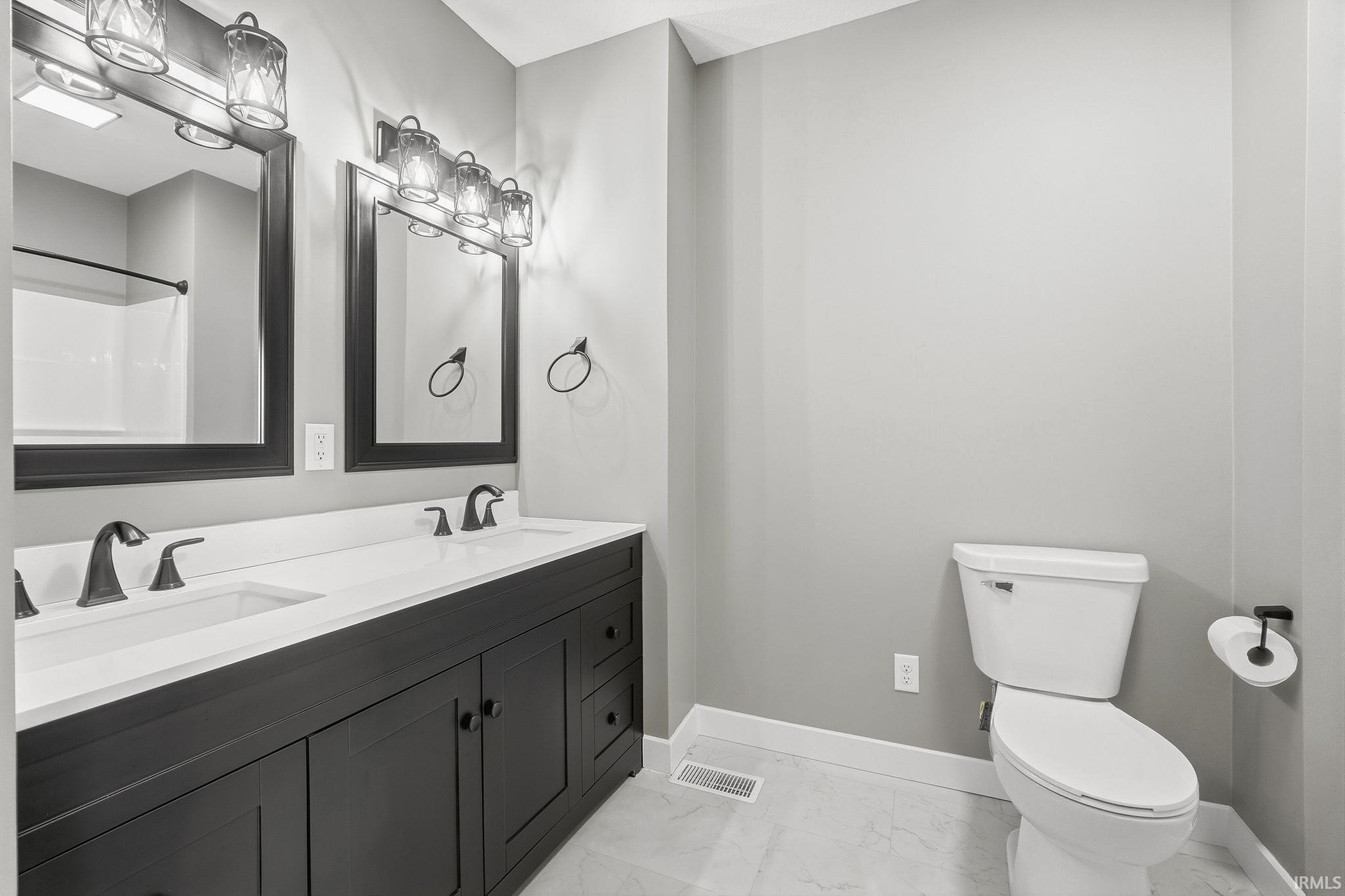 Full bathroom with double vanity, a shower, and light marble finish floors