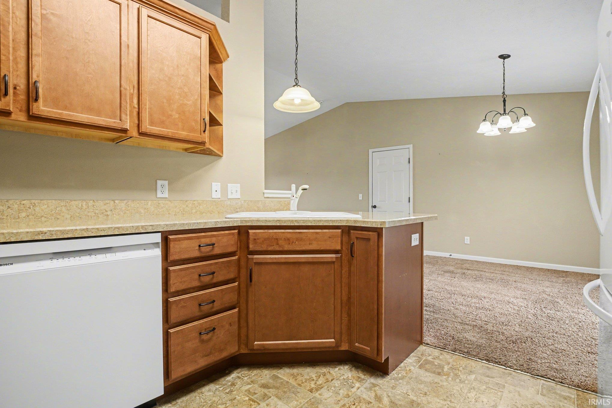 Kitchen featuring white appliances, light countertops, a peninsula, open shelves, and light carpet