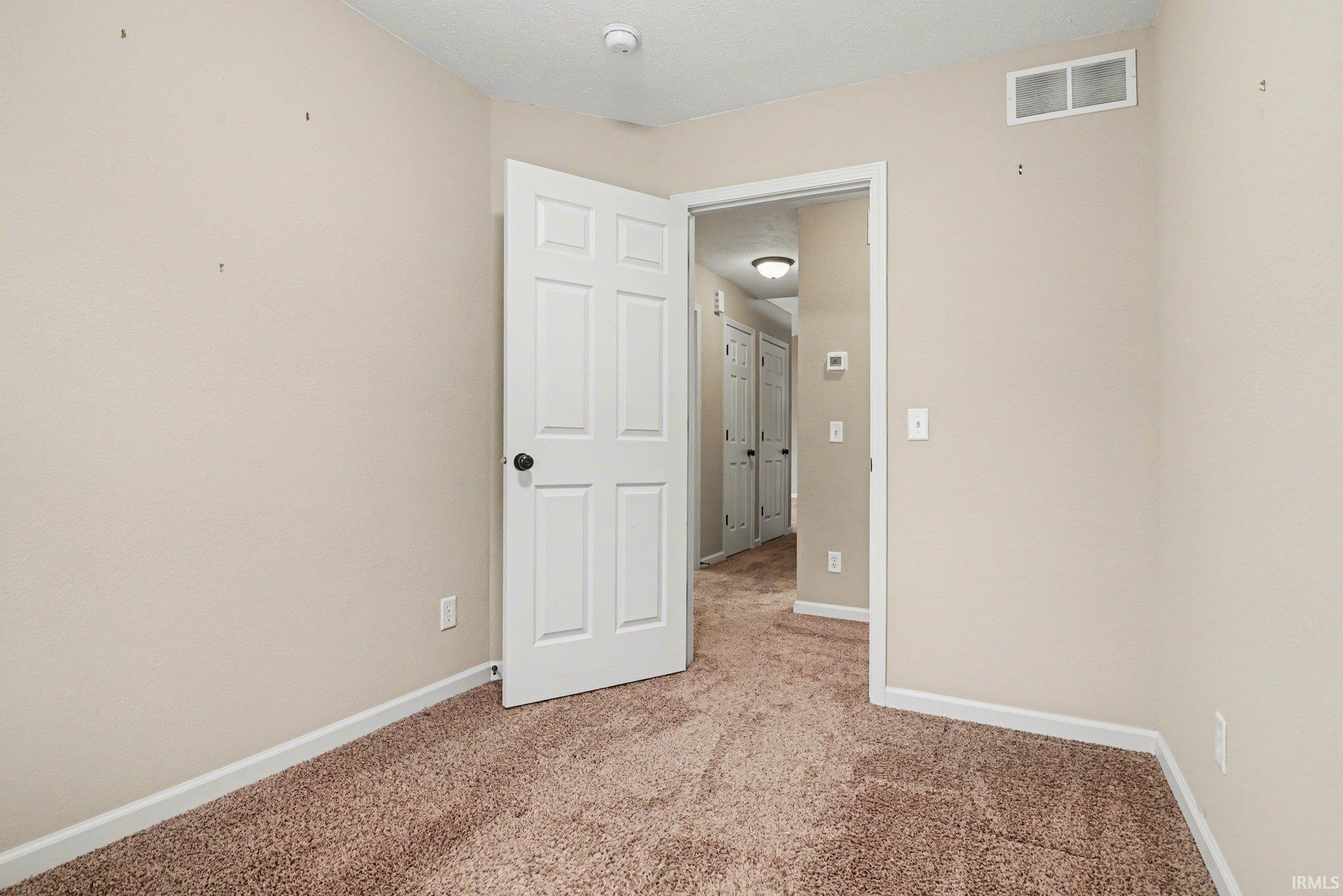 Unfurnished room featuring baseboards and light colored carpet