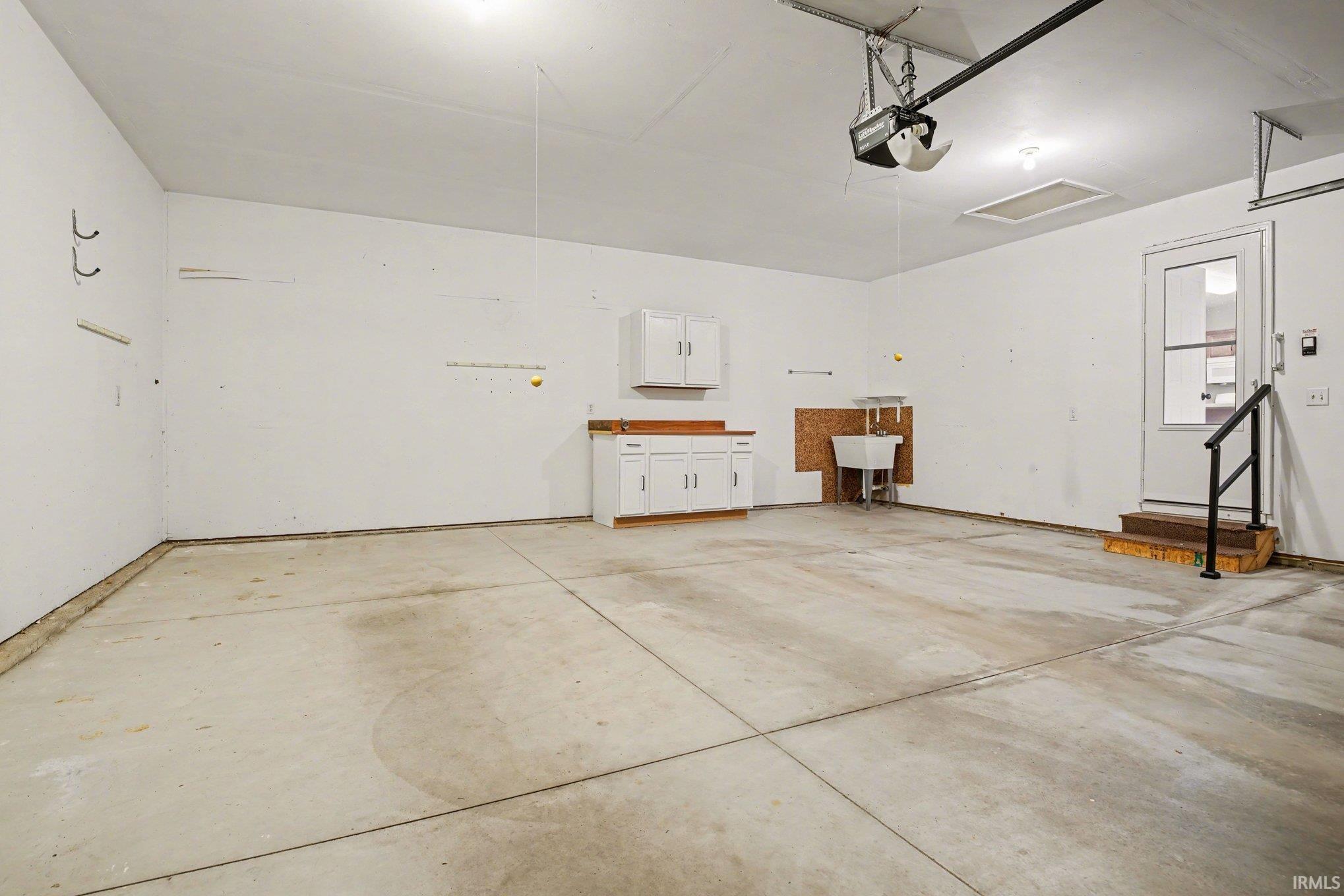 Garage featuring a garage door opener and a sink