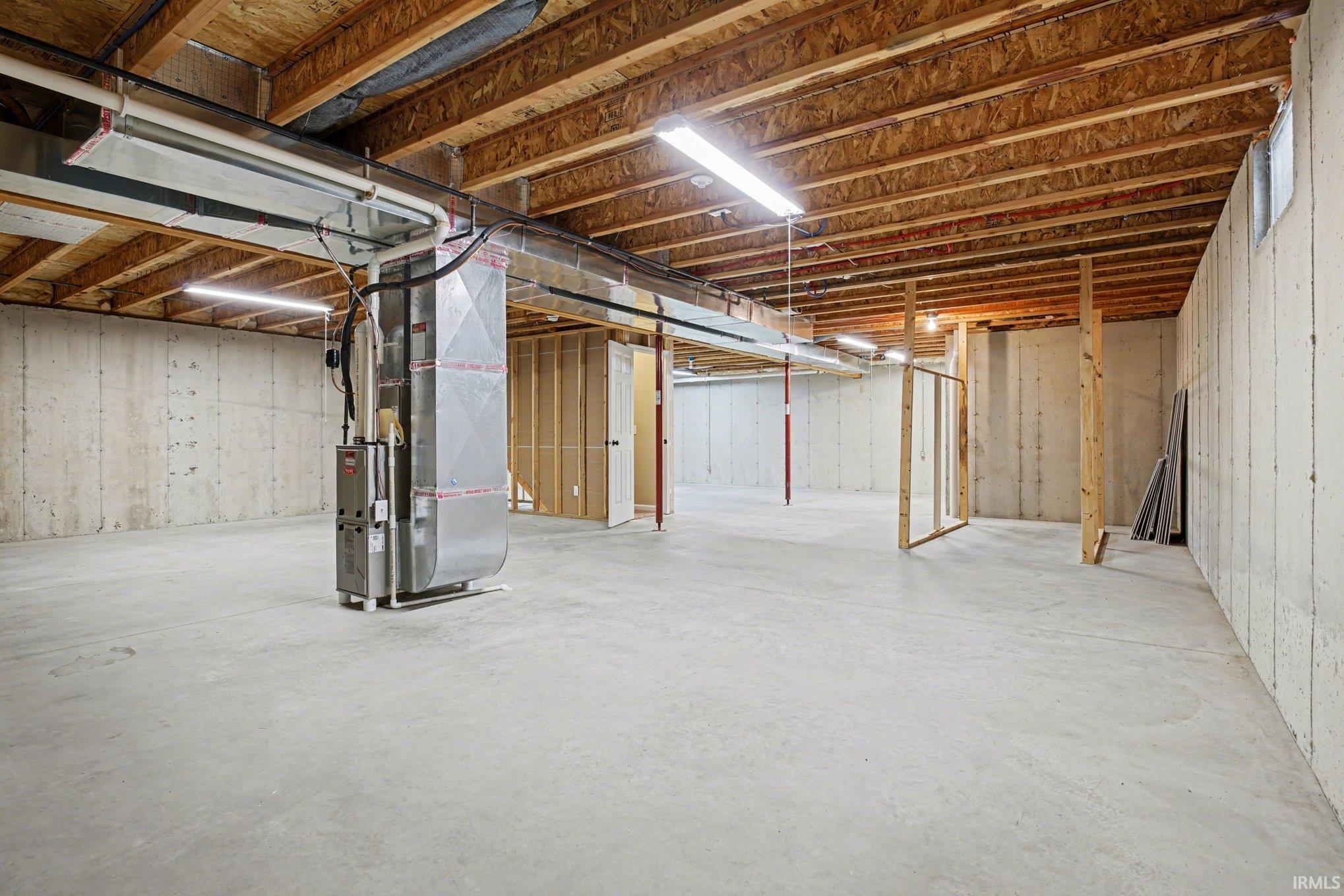 Unfinished below grade area featuring heating unit