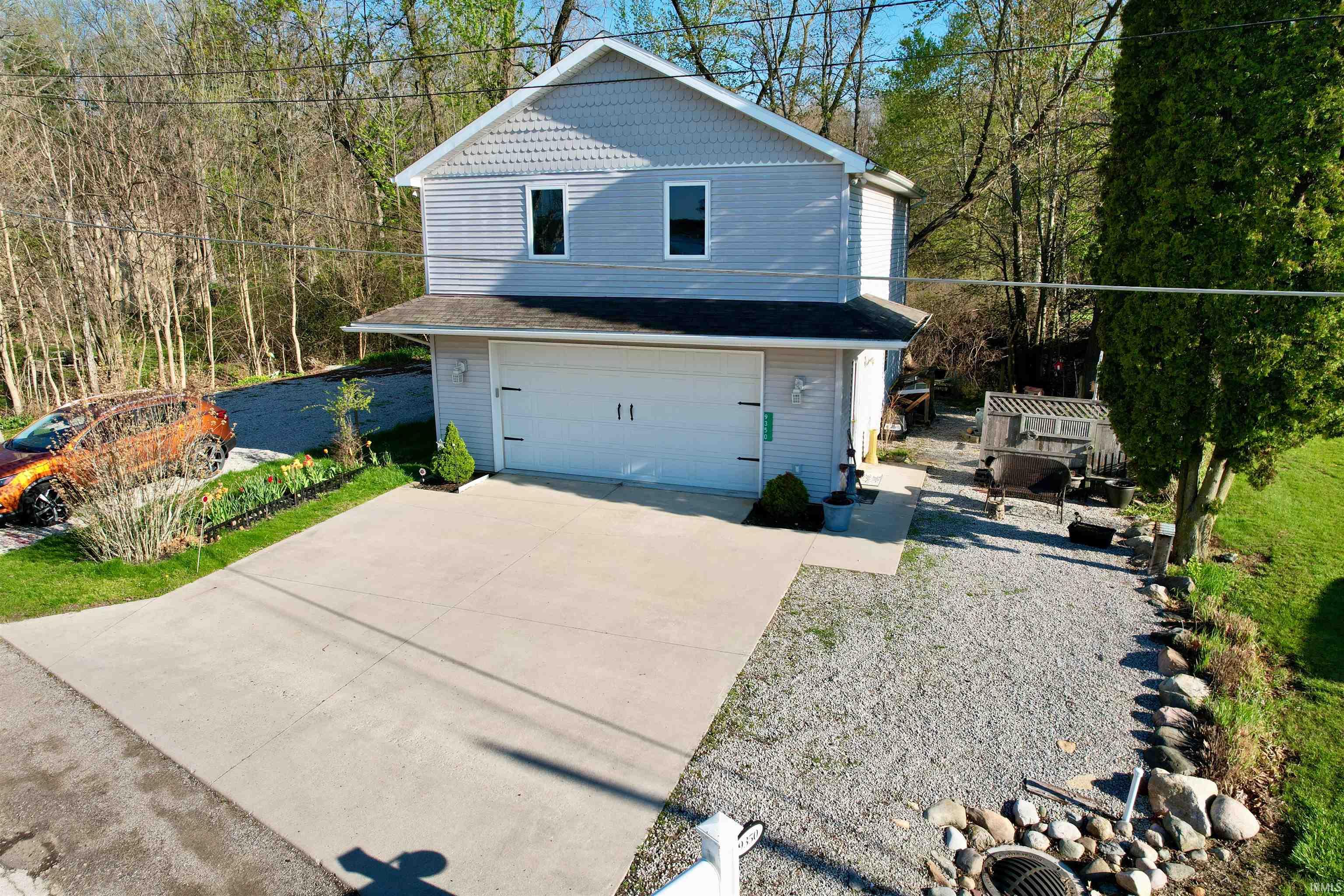 Two-story residence featuring light gray siding with shake accents on the upper level