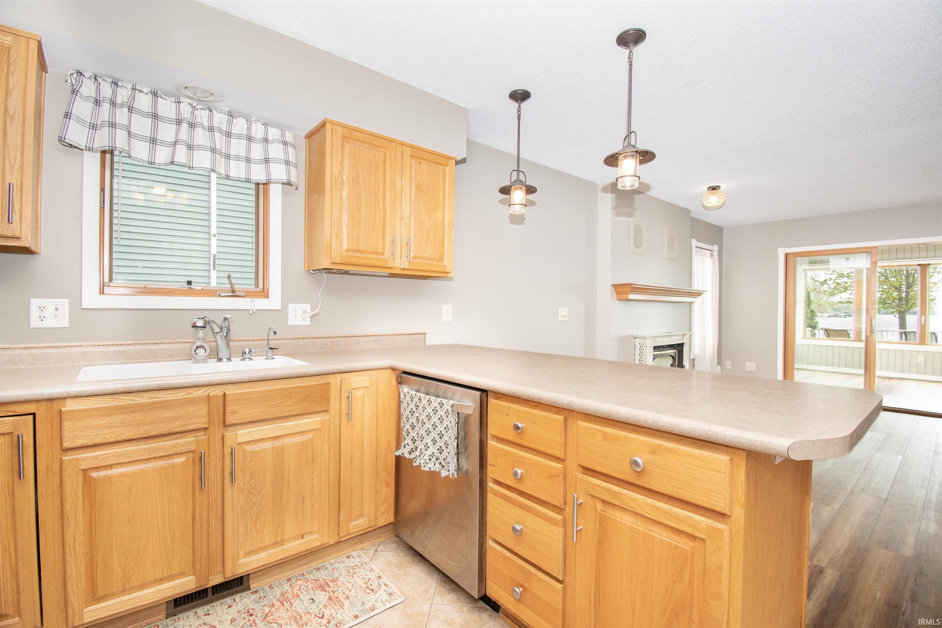 Kitchen featuring light wood cabinetry, a light-toned countertop with an integrated sink, and stainless steel appliances