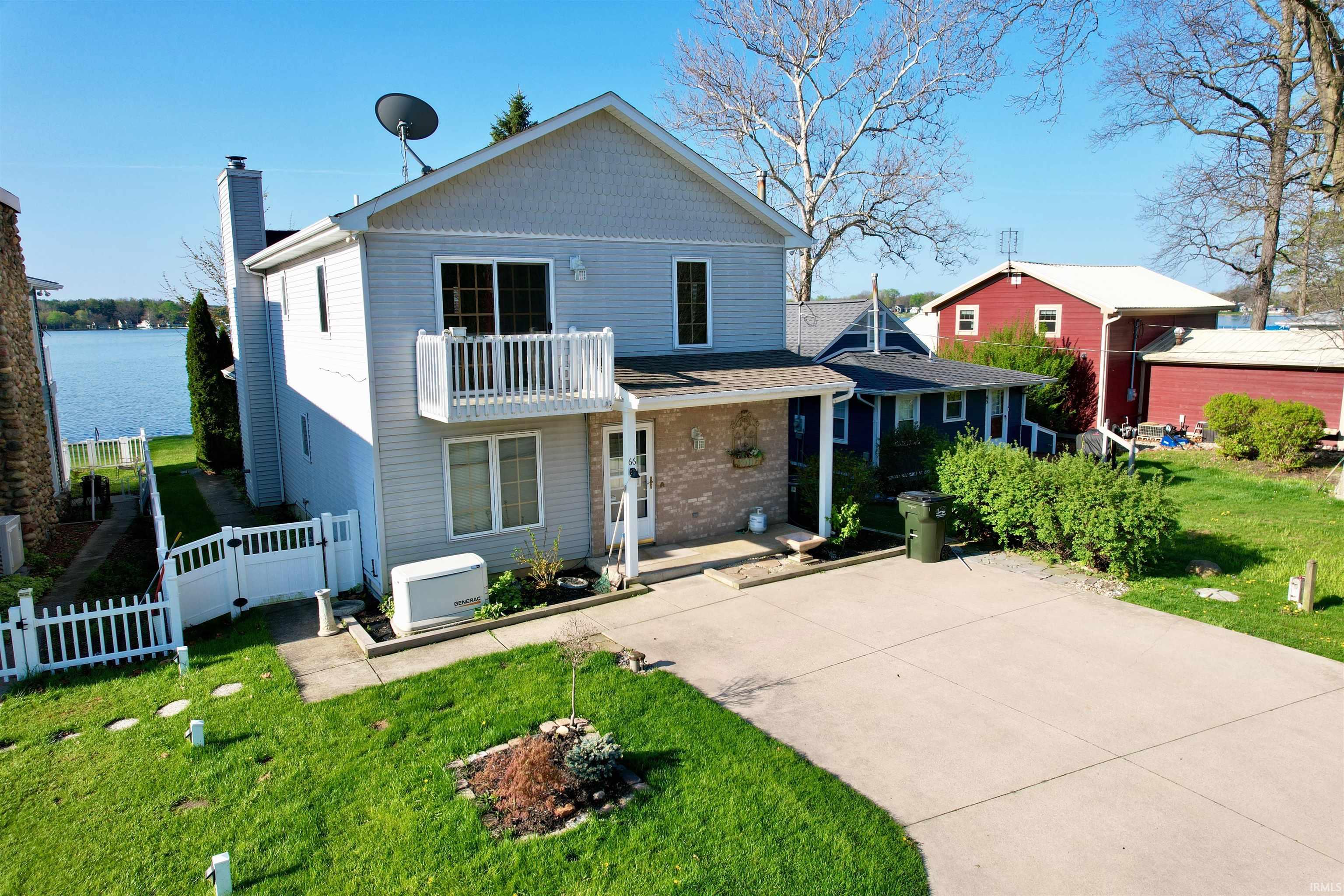 Two-story residence featuring light-colored siding and a balcony