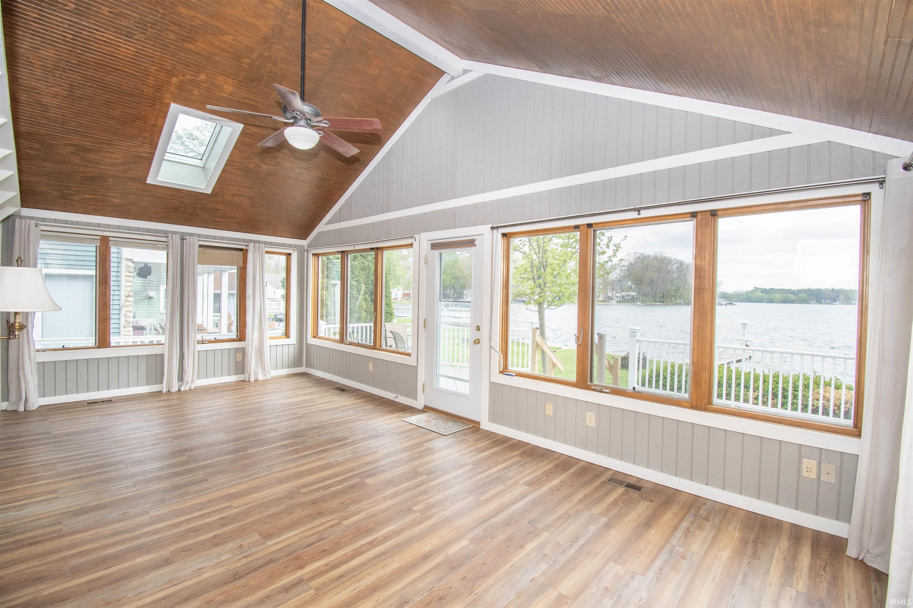Bright sunroom featuring abundant natural light, vaulted wood-finish ceiling, and skylight