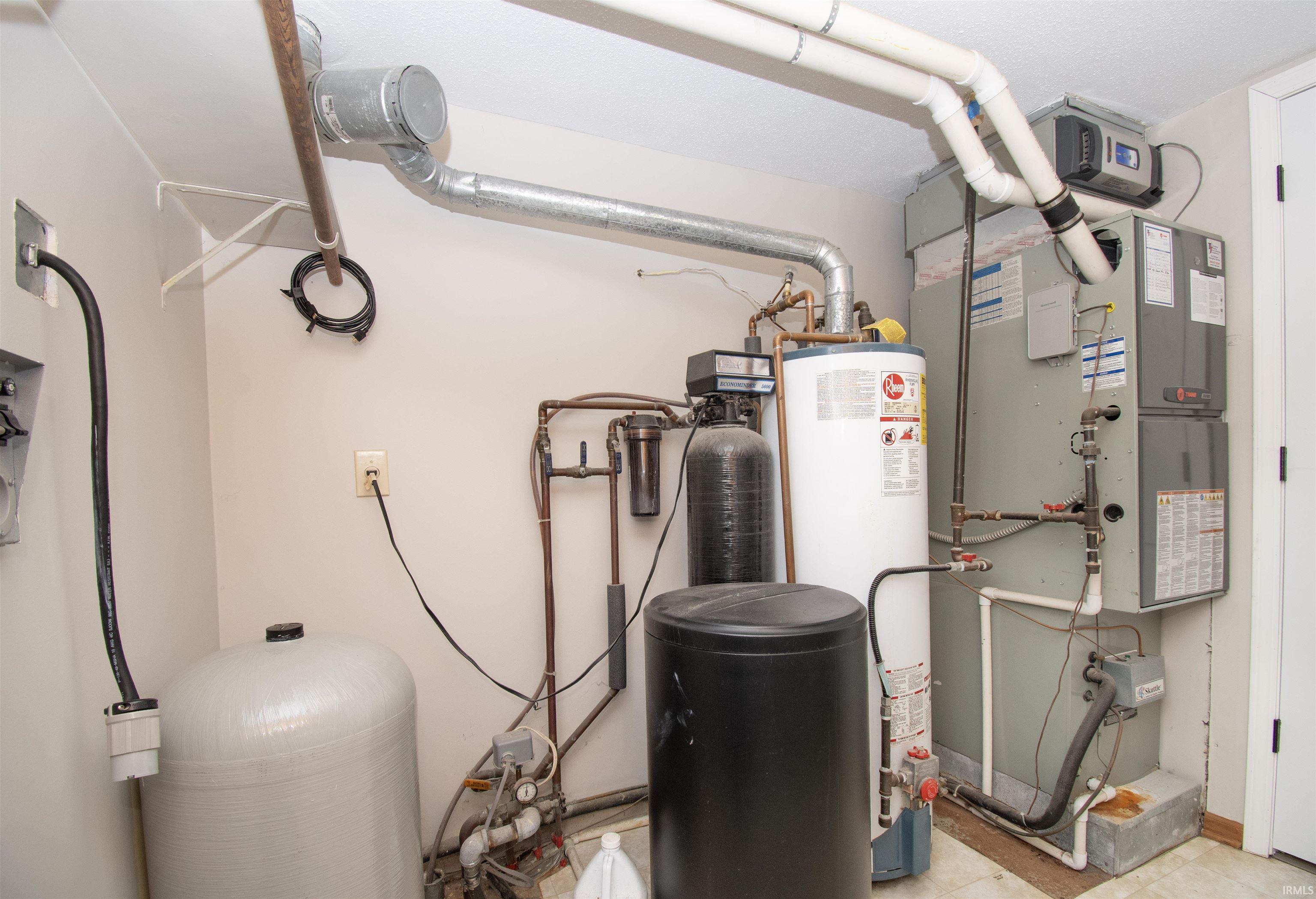 Dedicated utility space featuring a water heater, furnace, and water conditioning system