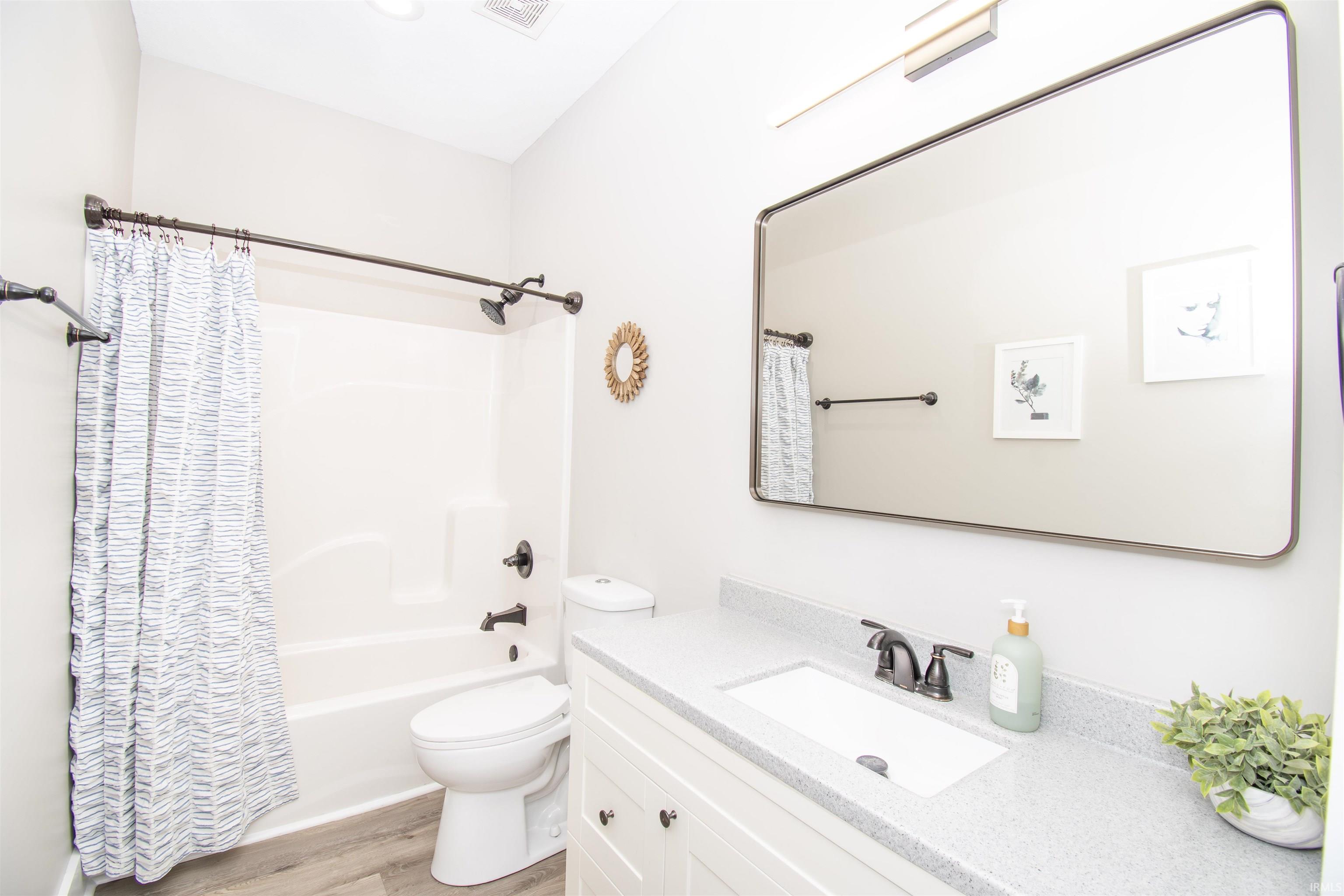 Bathroom featuring a white vanity with built-in sink, stone-finish countertop, and dark bronze-finish fixtures