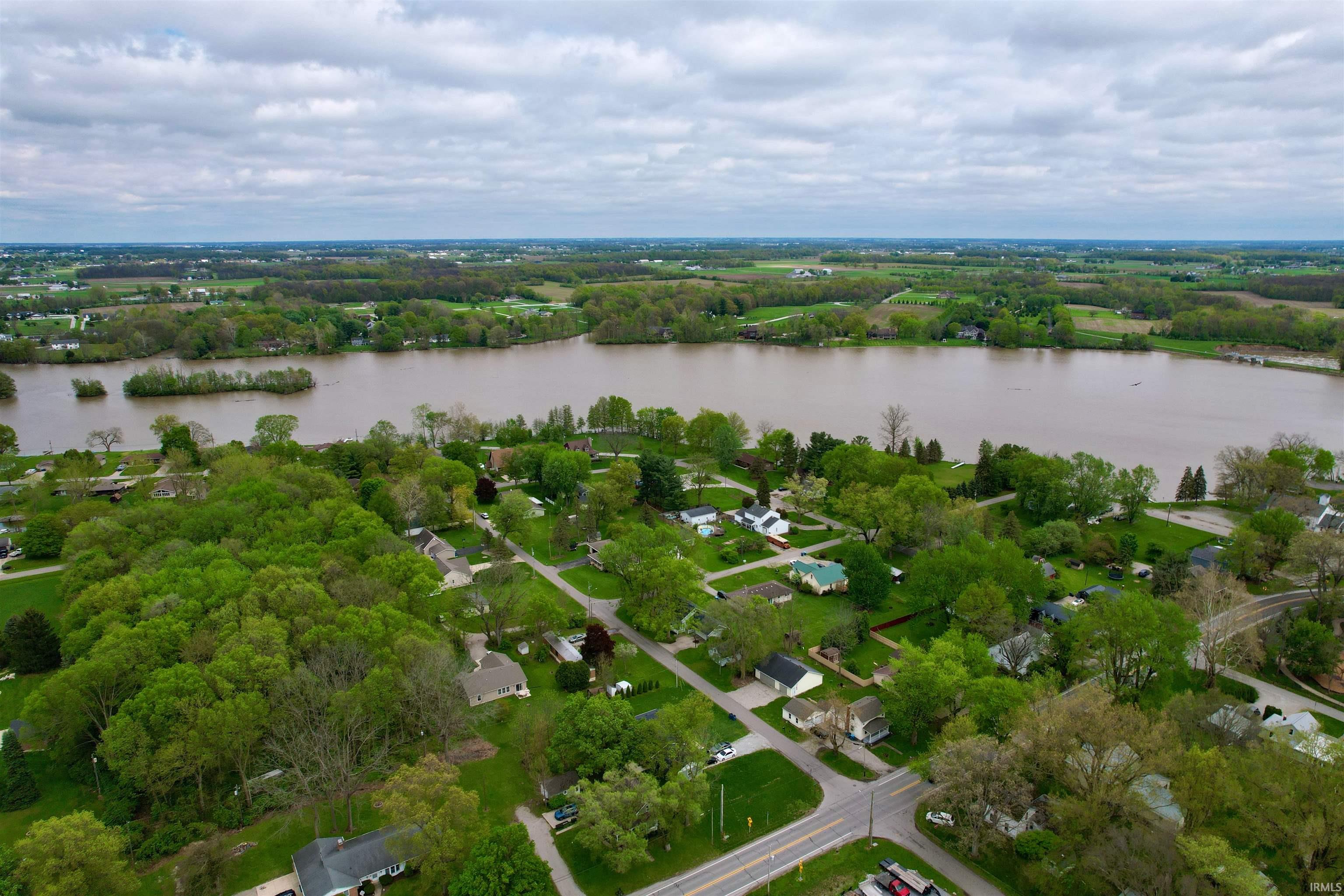 Aerial perspective showcasing a waterfront community with extensive green spaces and mature tree canopies