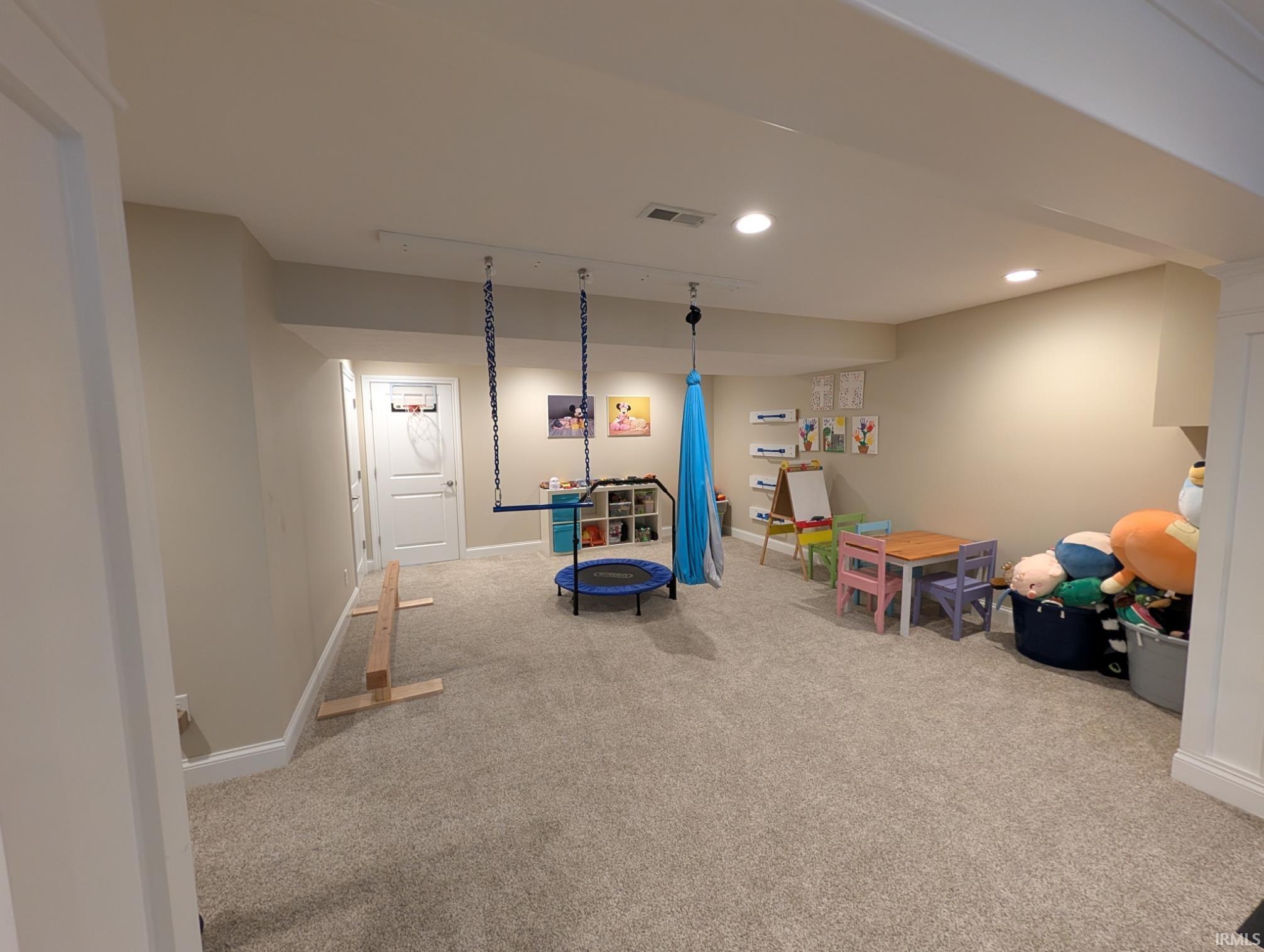 Spacious finished lower level featuring recessed lighting, light-toned walls, and carpet flooring
