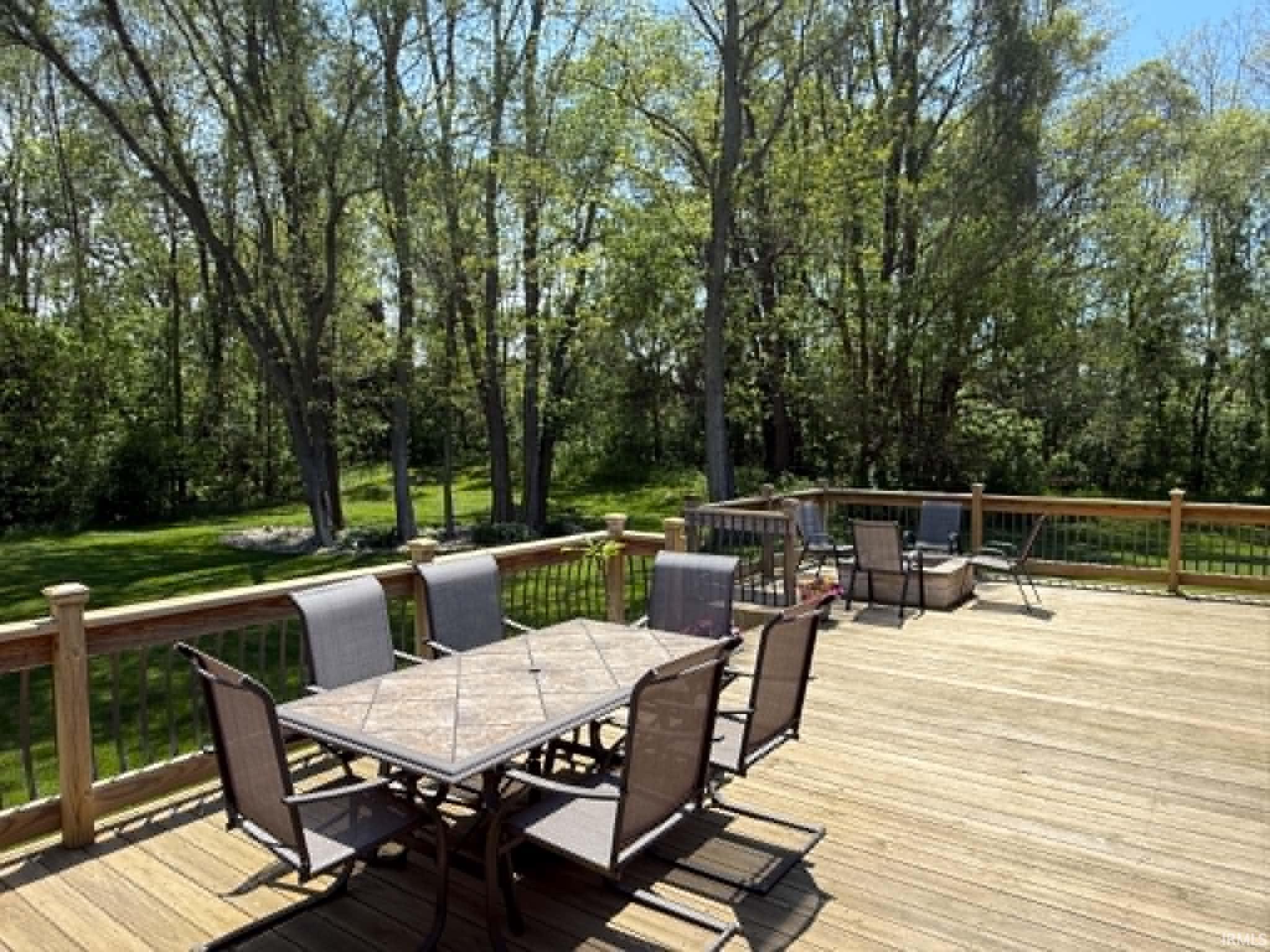 Expansive wood deck with natural wood railing and black metal balusters