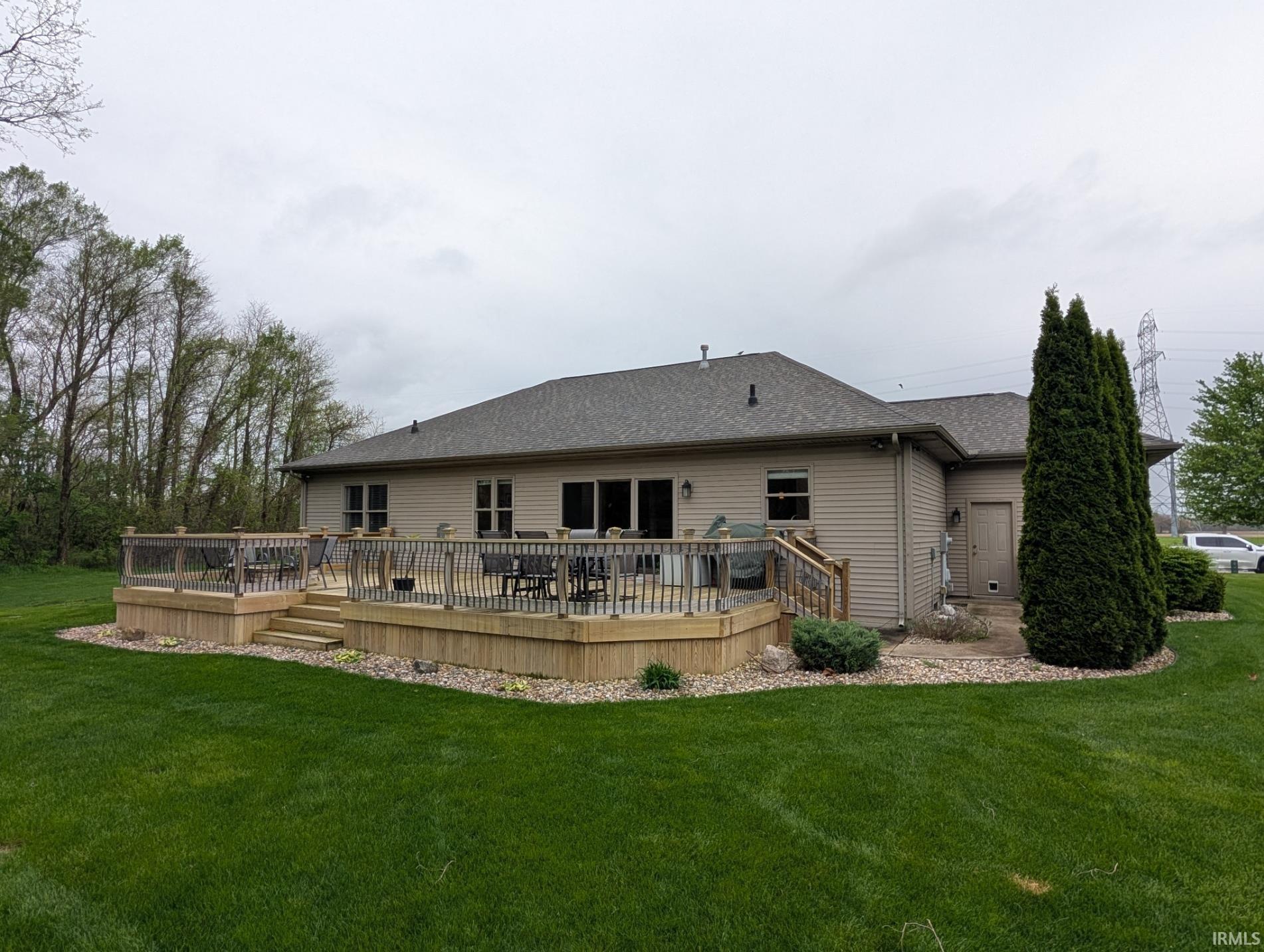 Multi-level wooden deck featuring glass panel railings and built-in steps