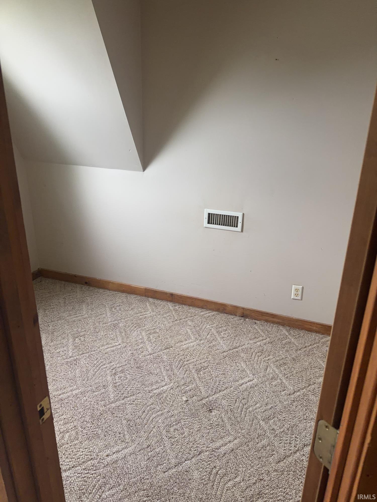 Carpeted room with a textured pattern and light-toned walls