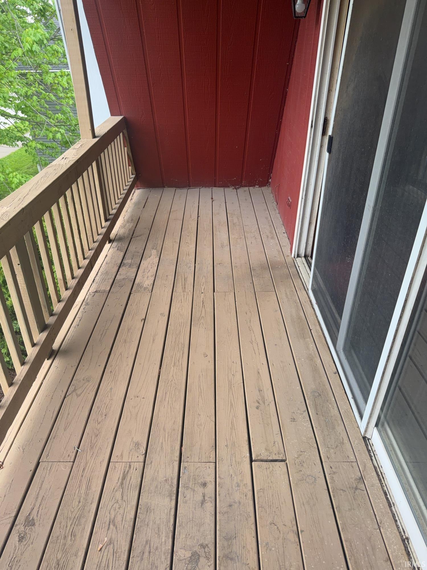 Outdoor balcony featuring wood decking and a wood-finish railing