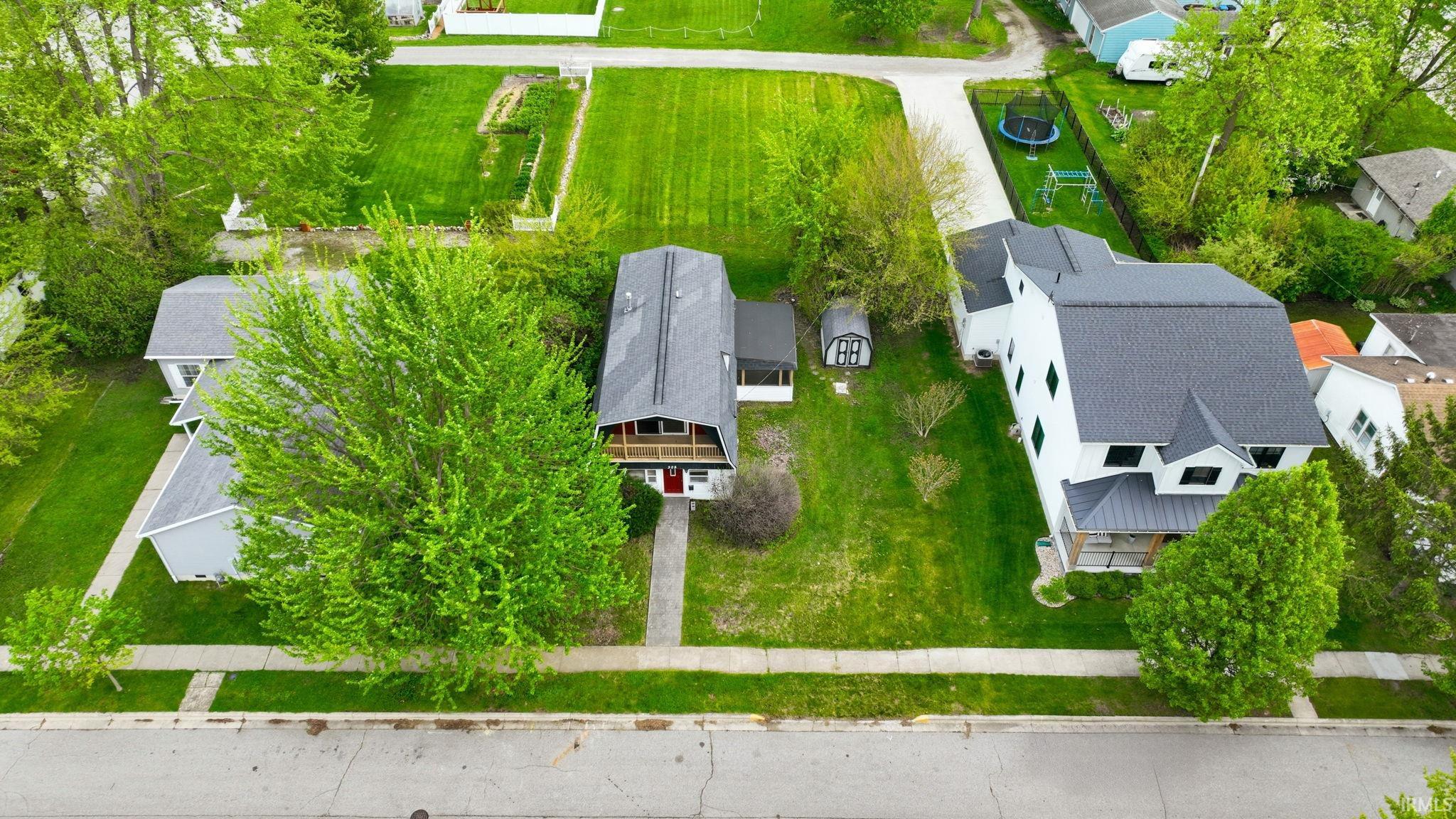 Property features a two-story residence with a dark shingled roof, a front-facing balcony, and a red entry door