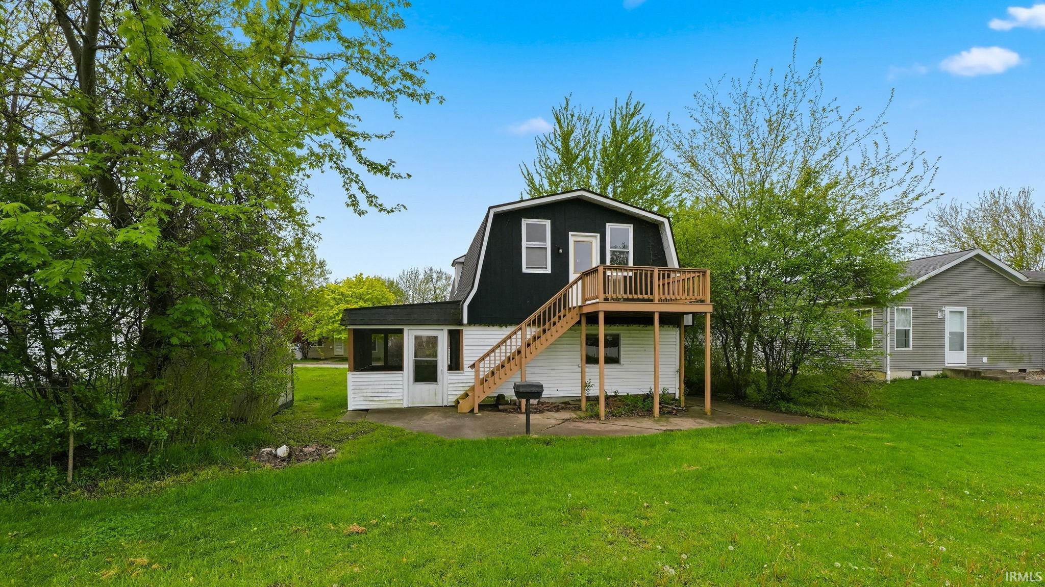 Two-story property featuring a gambrel roof and white siding