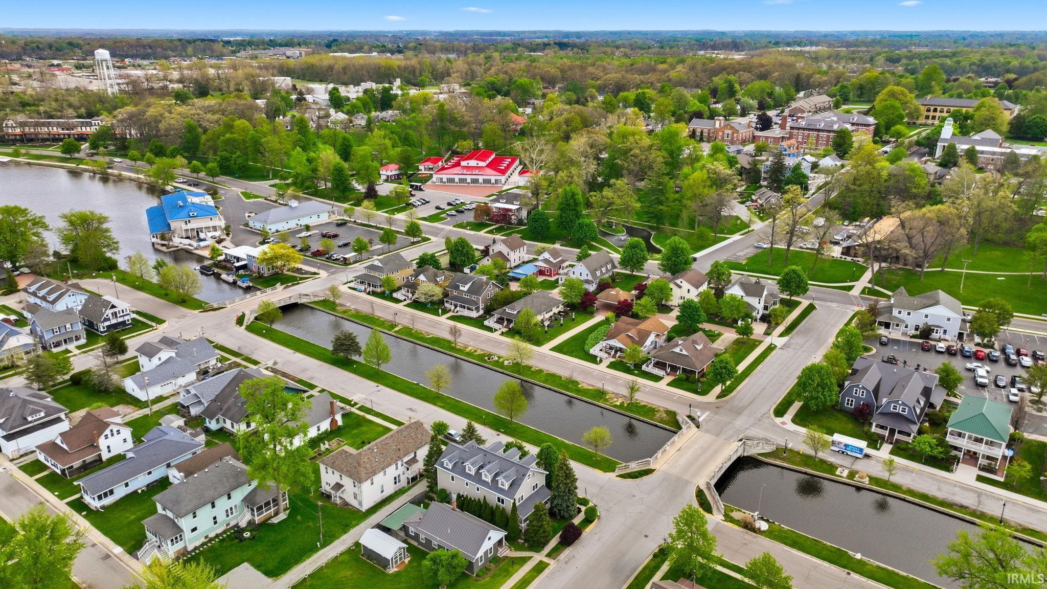 Aerial depiction of a residential area with canal access, featuring several properties with private docks