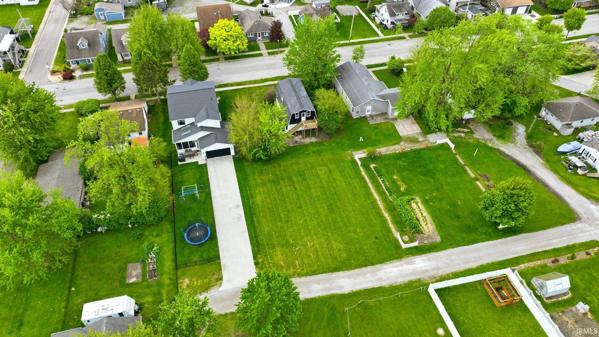 Contemporary residence featuring a paved driveway, attached garage, and a large front lawn