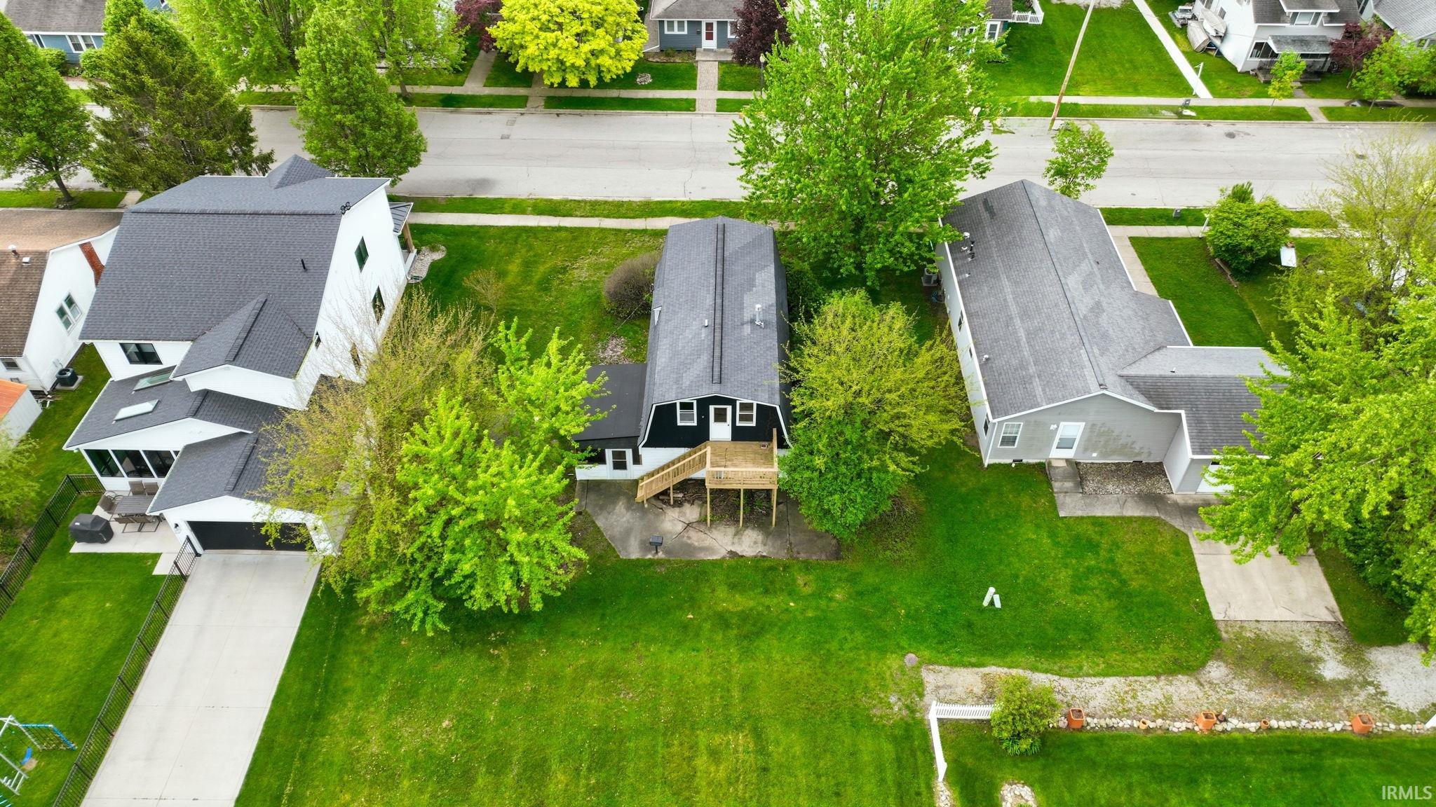 Contemporary residence featuring a screened porch, attached garage, and mature landscaping