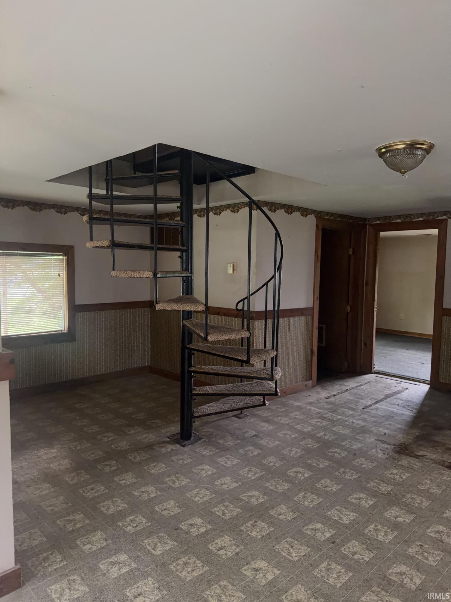 Black metal spiral staircase with carpeted treads
