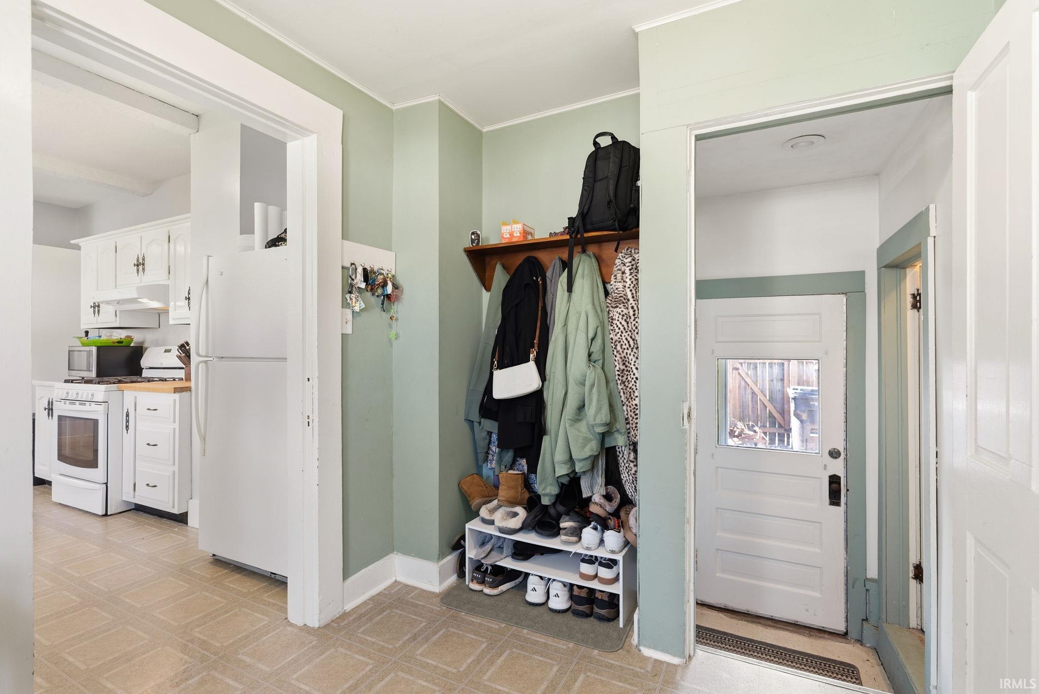 Mudroom featuring light floors and ornamental molding