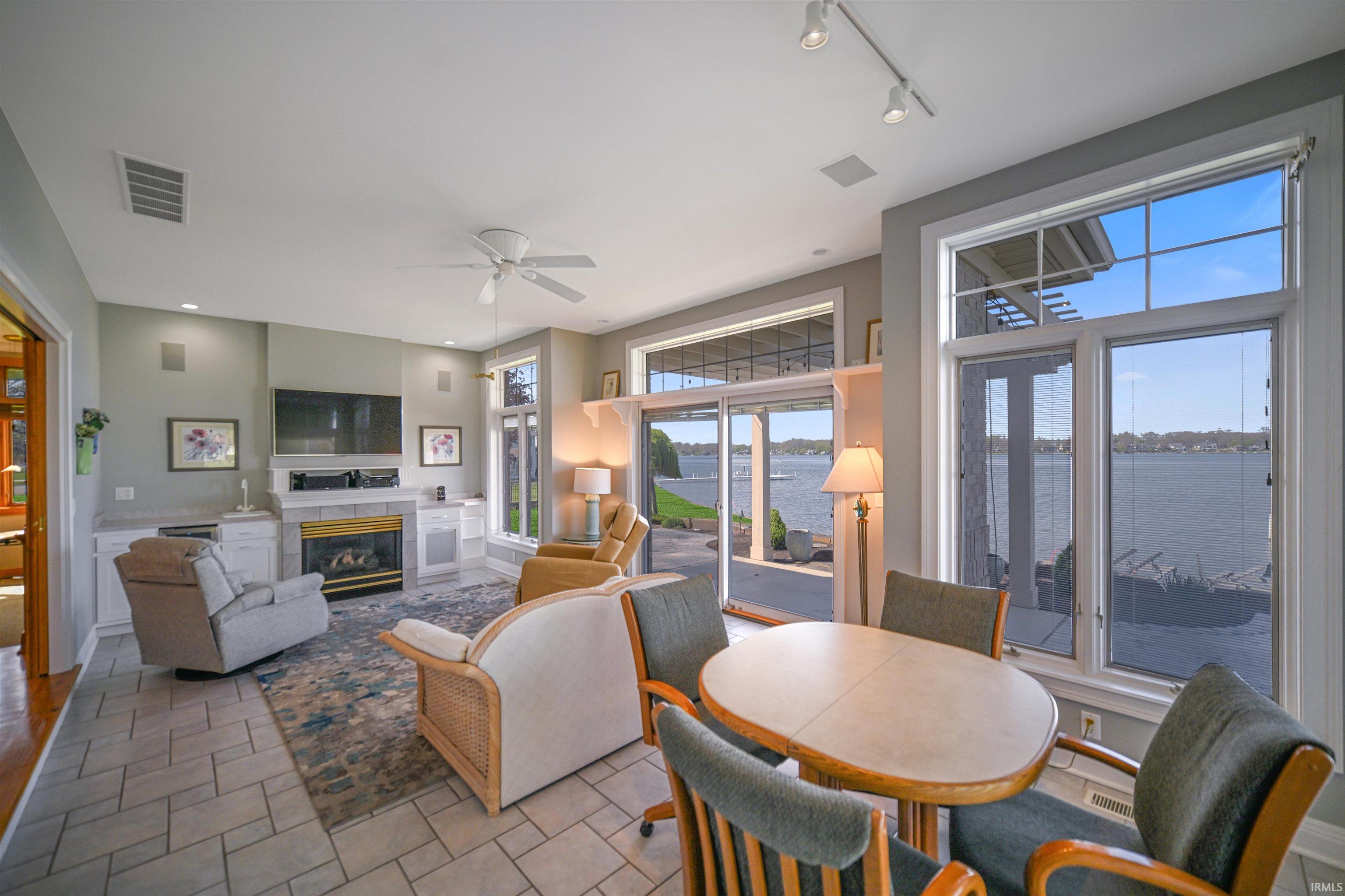 Expansive living area featuring a direct waterfront outlook, large picture windows, and sliding glass doors