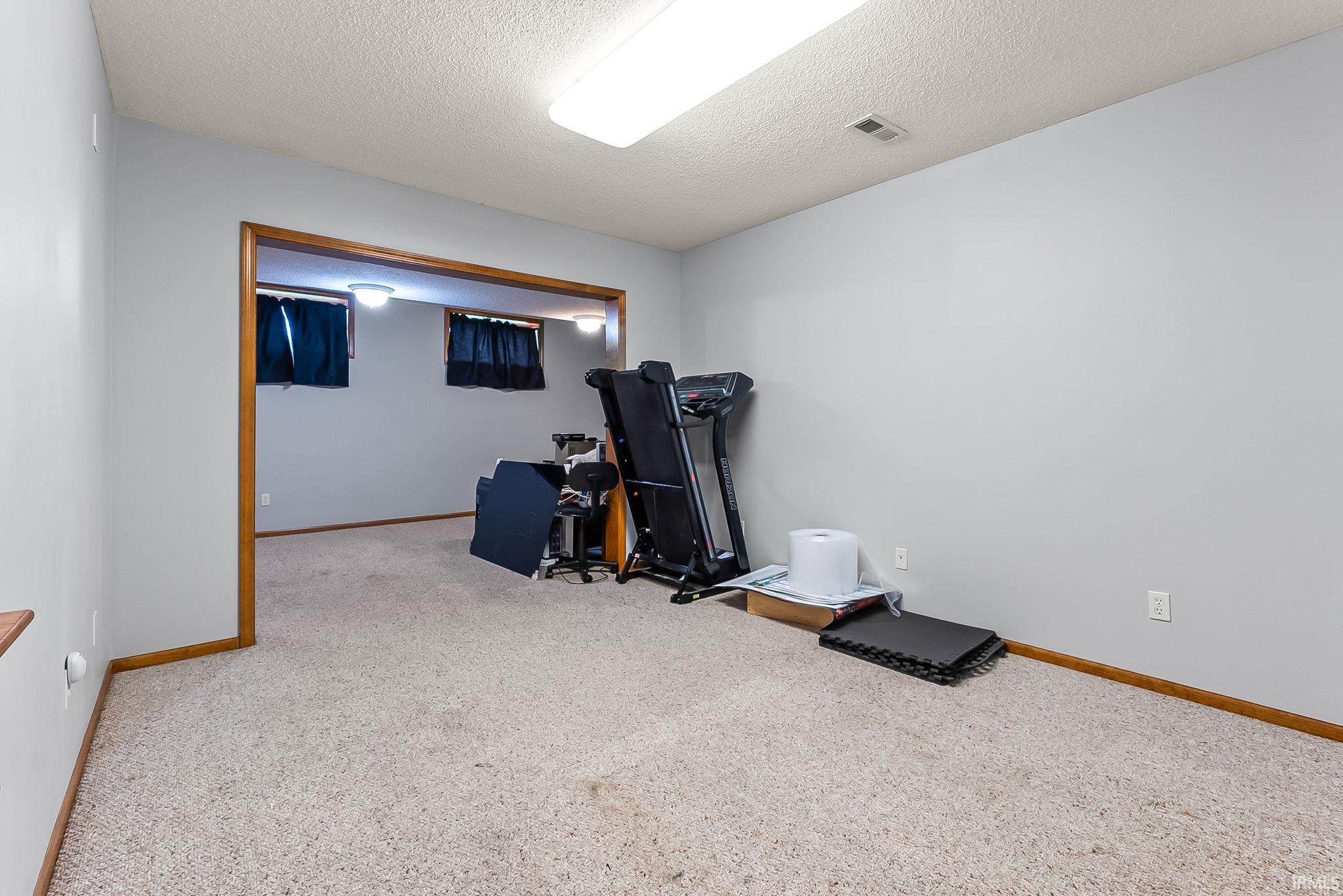 Carpeted room with light gray walls and wood trim