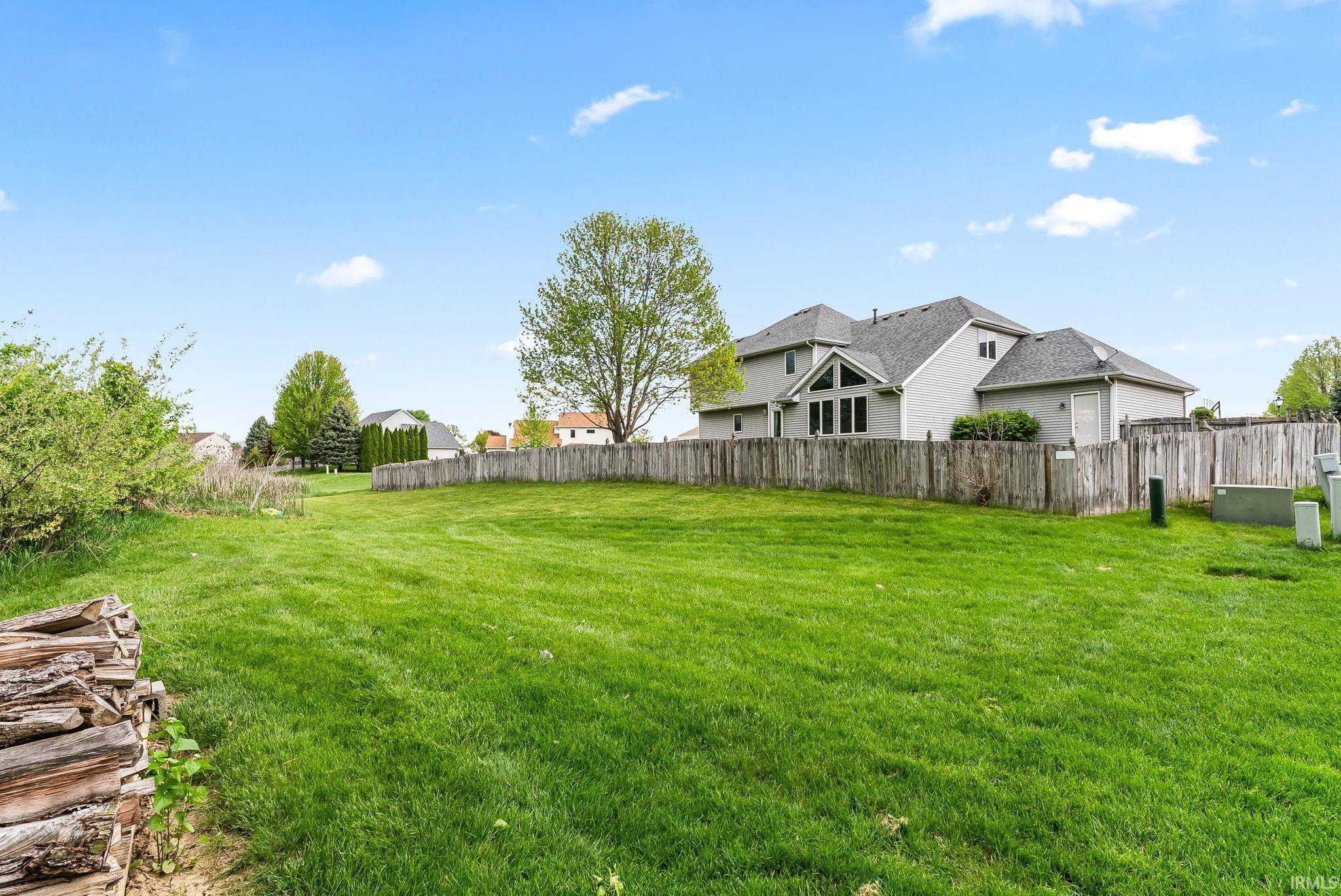 Expansive green lawn with a privacy fence bordering the property