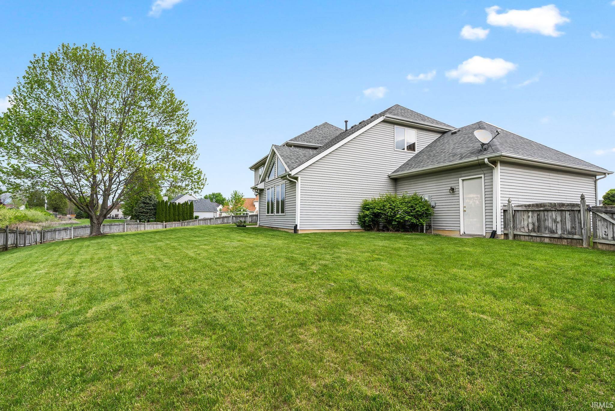 Expansive green lawn bordering a gray siding exterior