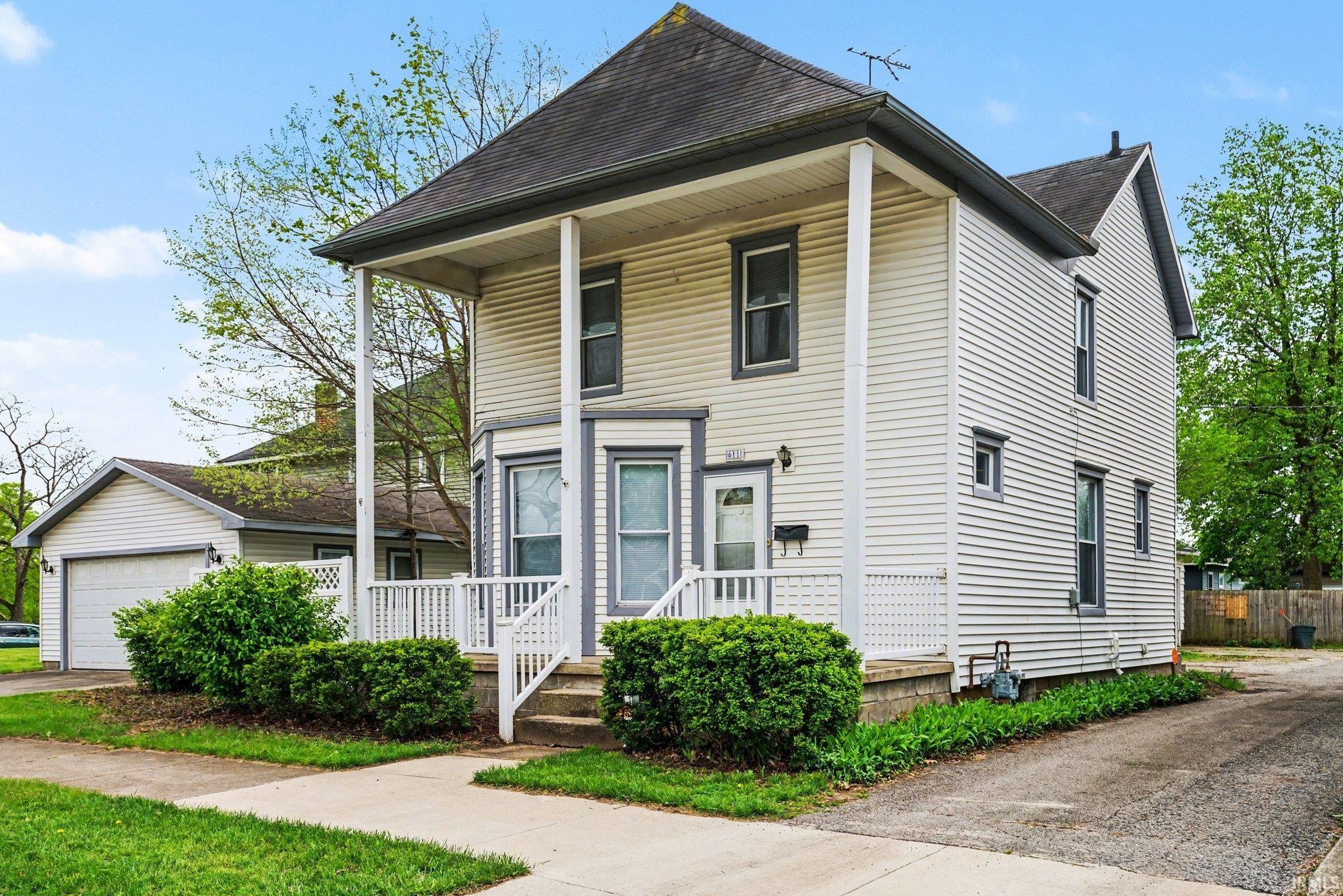 Two-story residence featuring white siding and a covered front porch with white railings