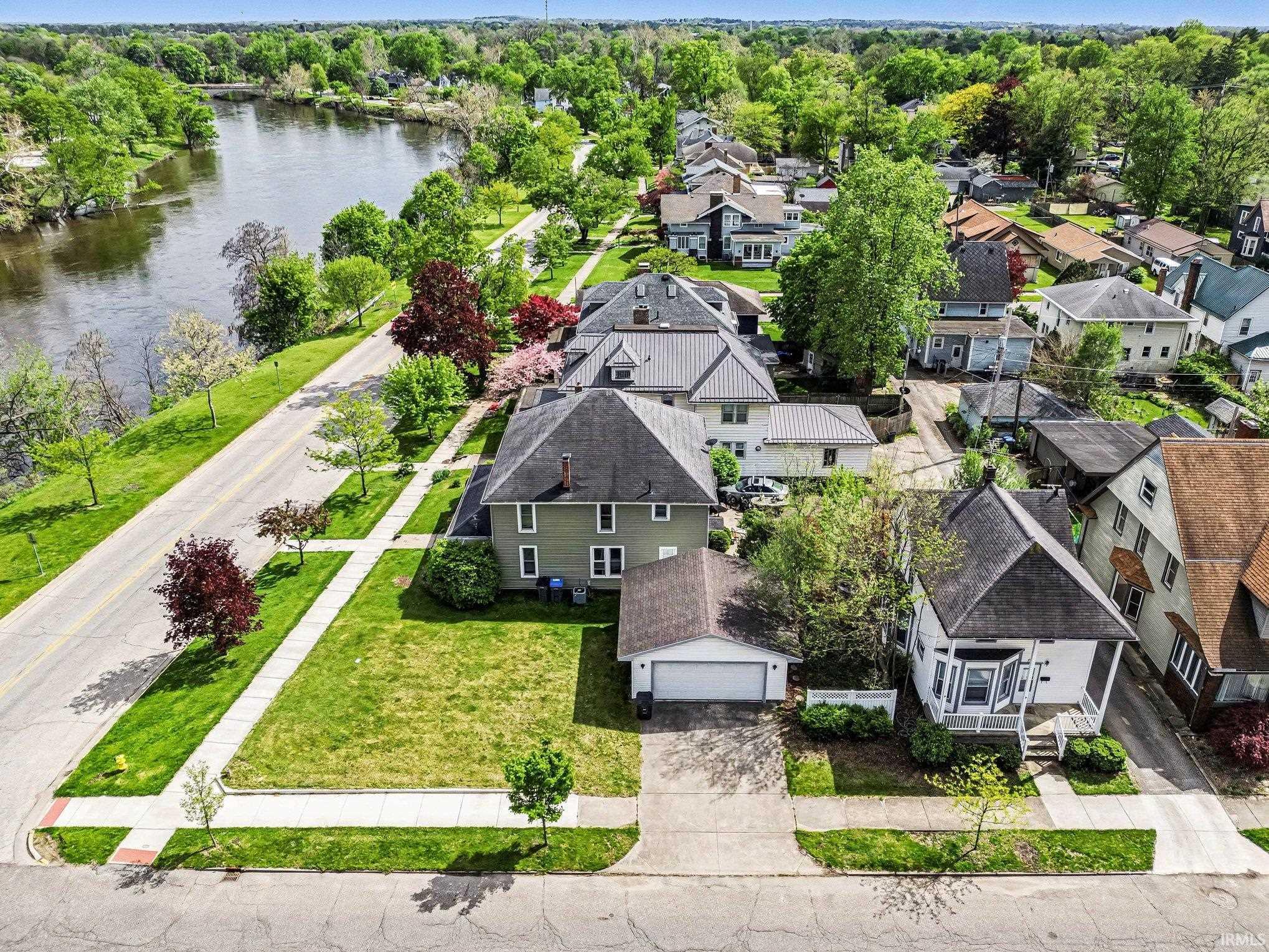 Aerial perspective showcasing a residential street with a prominent riverfront