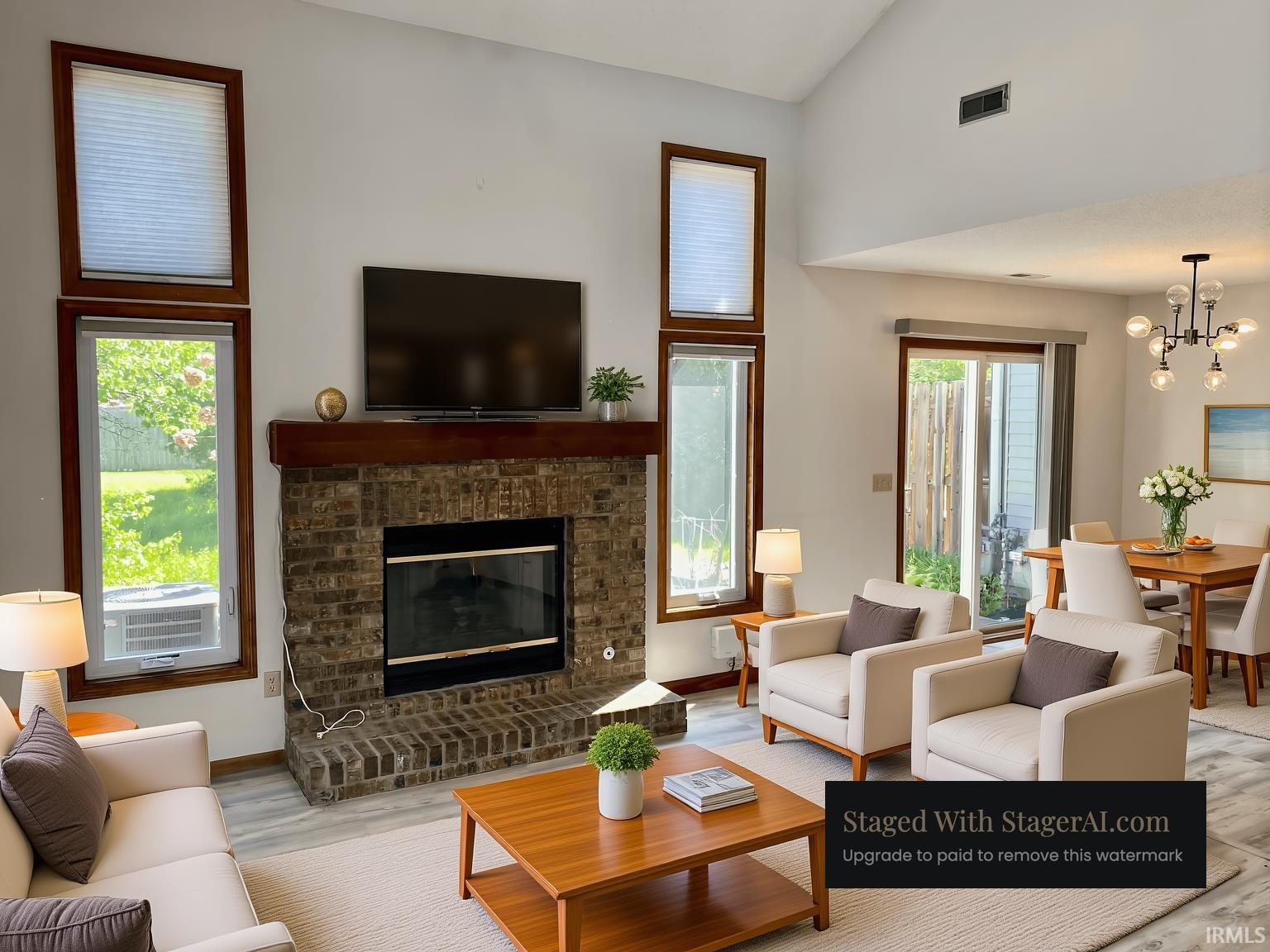 Living area featuring a brick-surround fireplace with a wood mantel, vaulted ceilings, and large windows with wood-finish trim