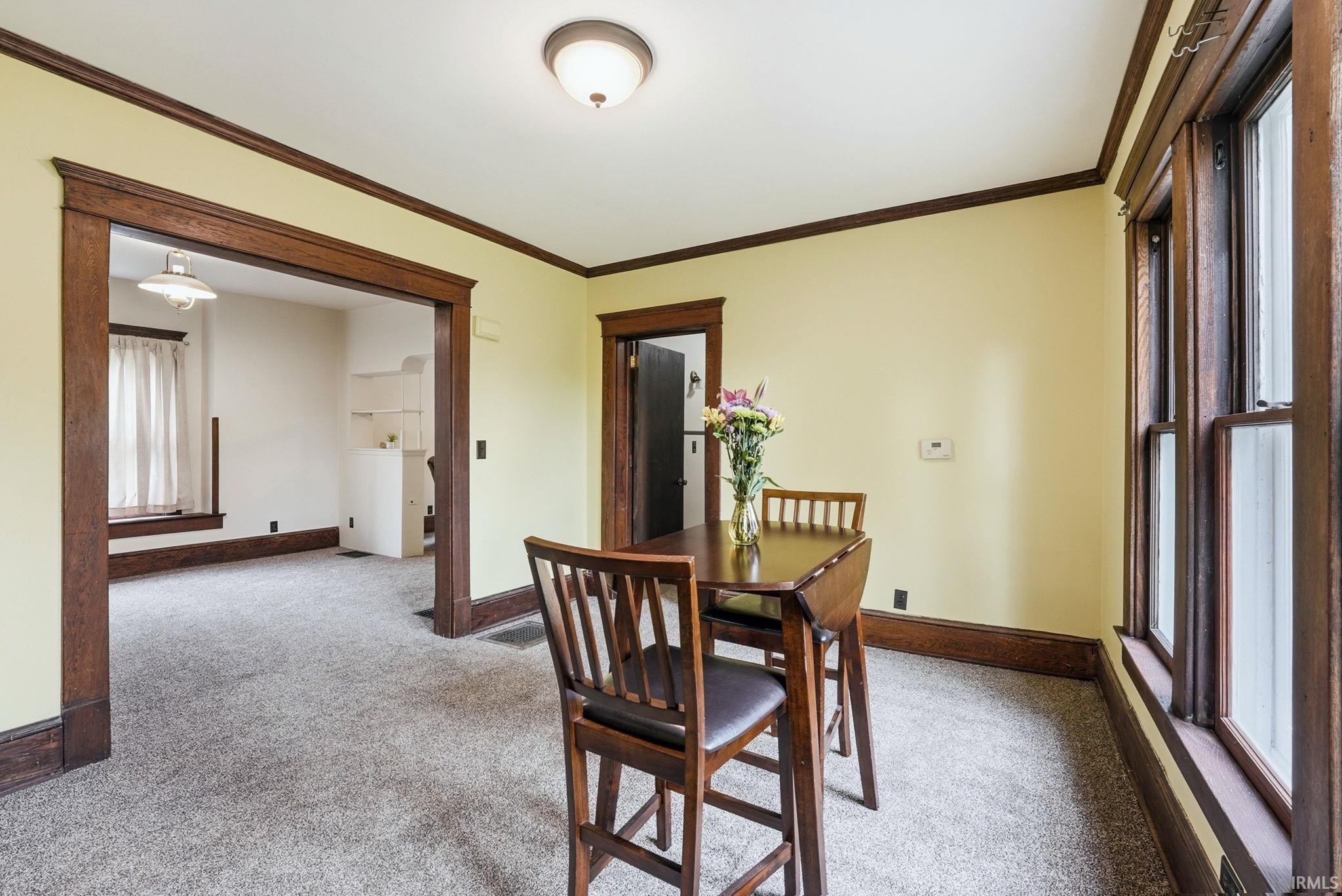 Dining area featuring light-colored walls and dark wood trim