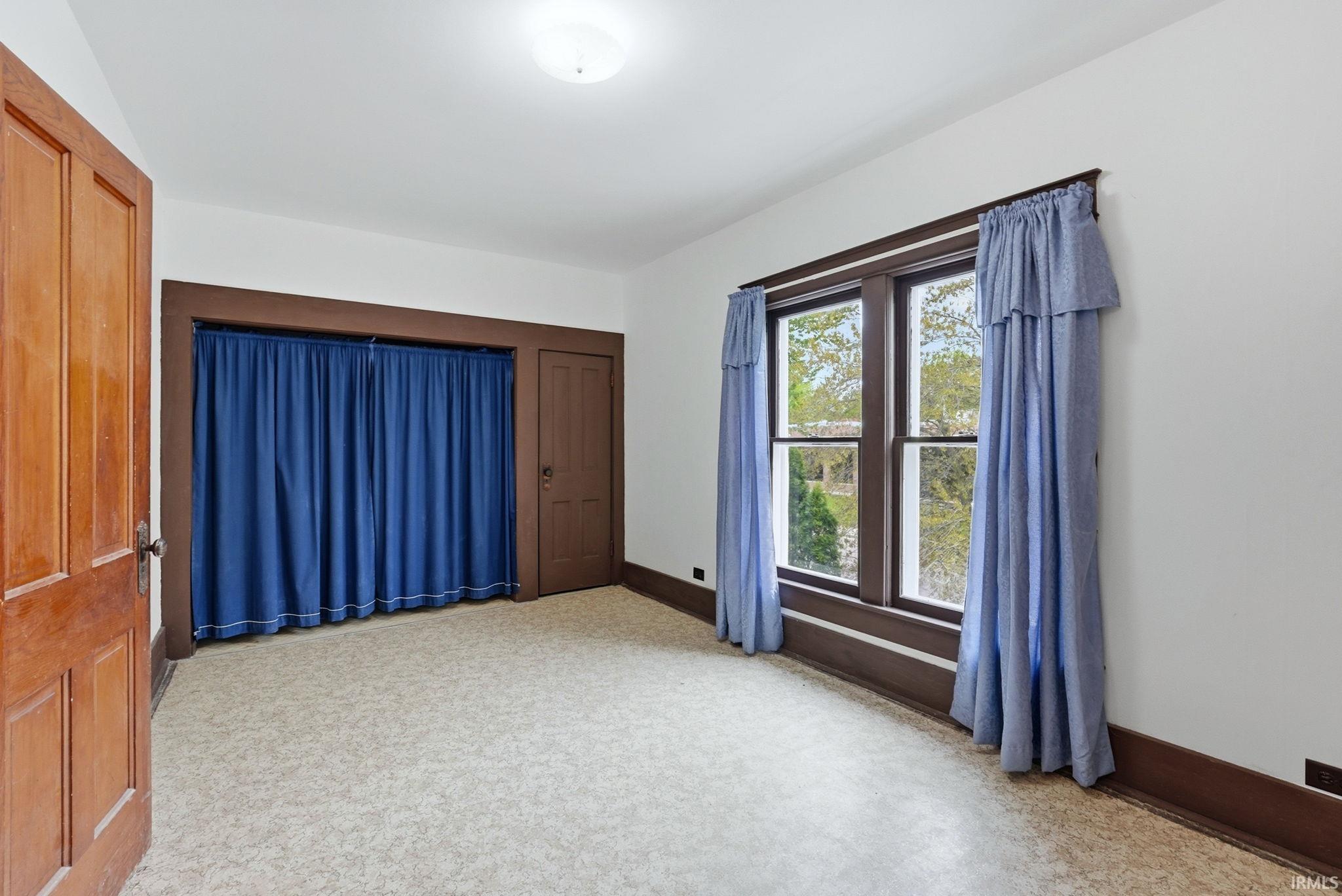 Neutral wall finishes complement the patterned carpeting in this bright room