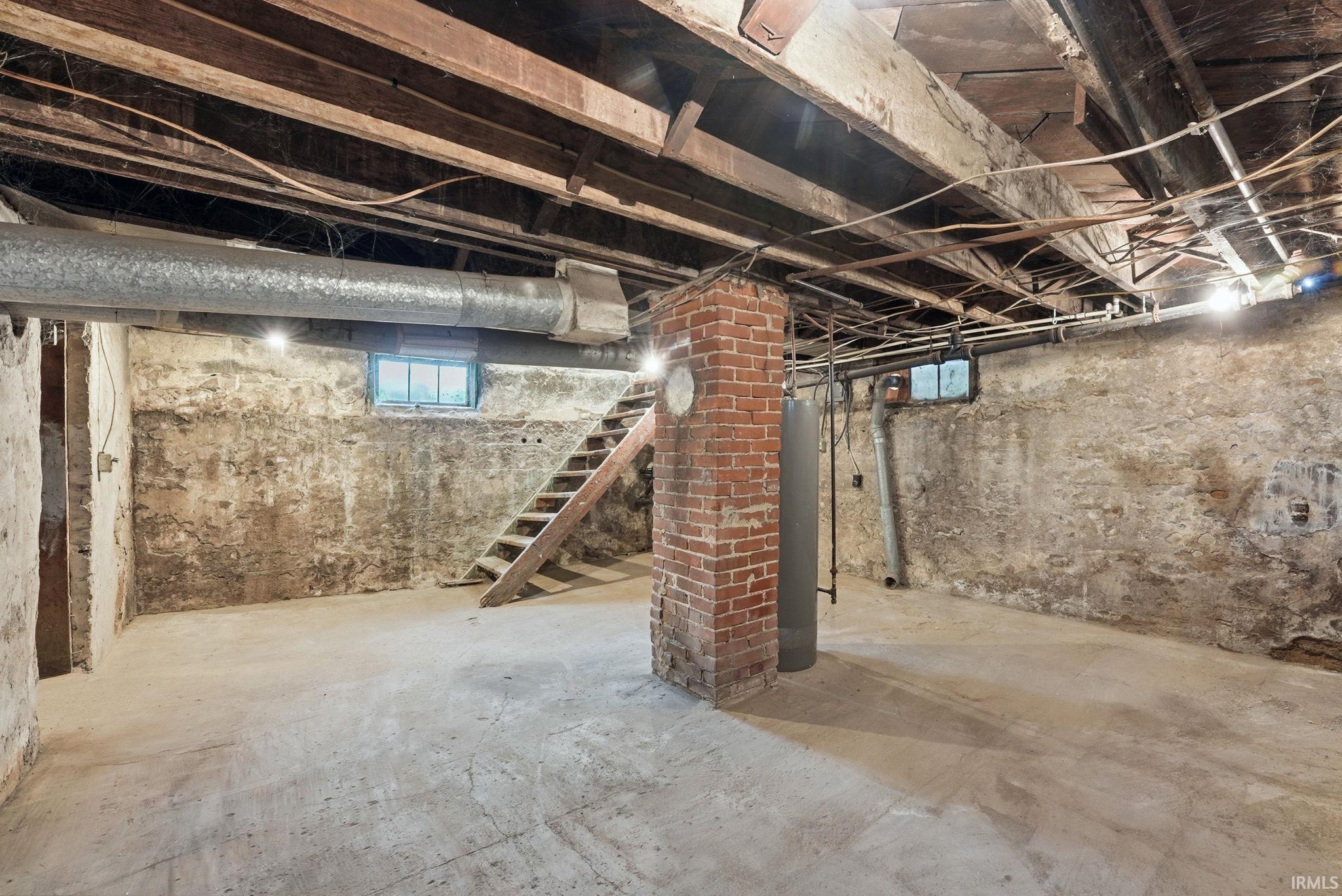 Unfinished basement space with exposed ceiling joists and concrete flooring