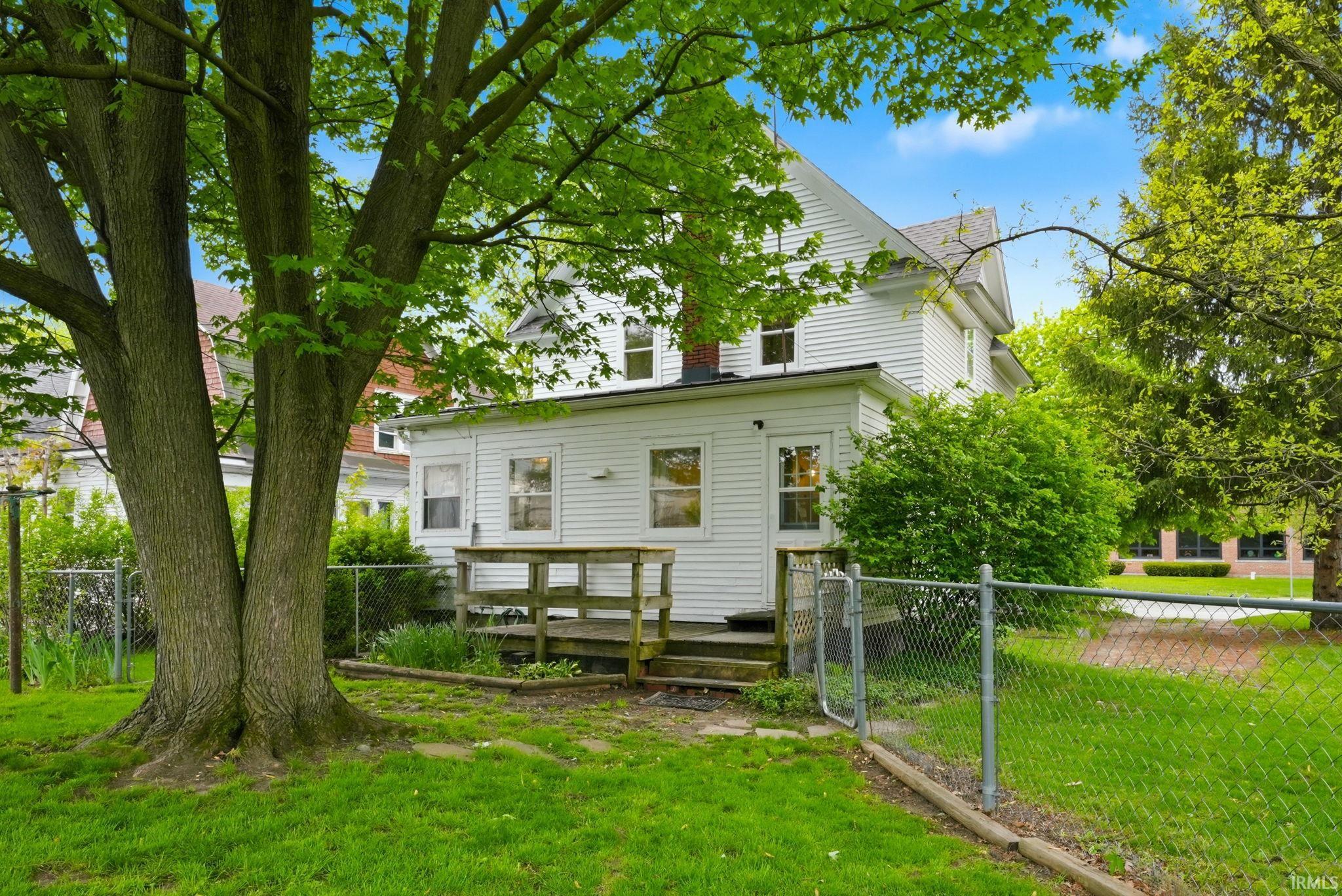 Expansive green lawn with a mature tree
