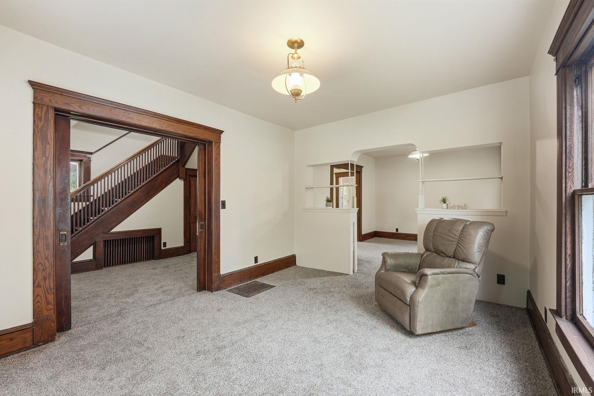 Spacious room featuring light-colored walls and plush carpeting