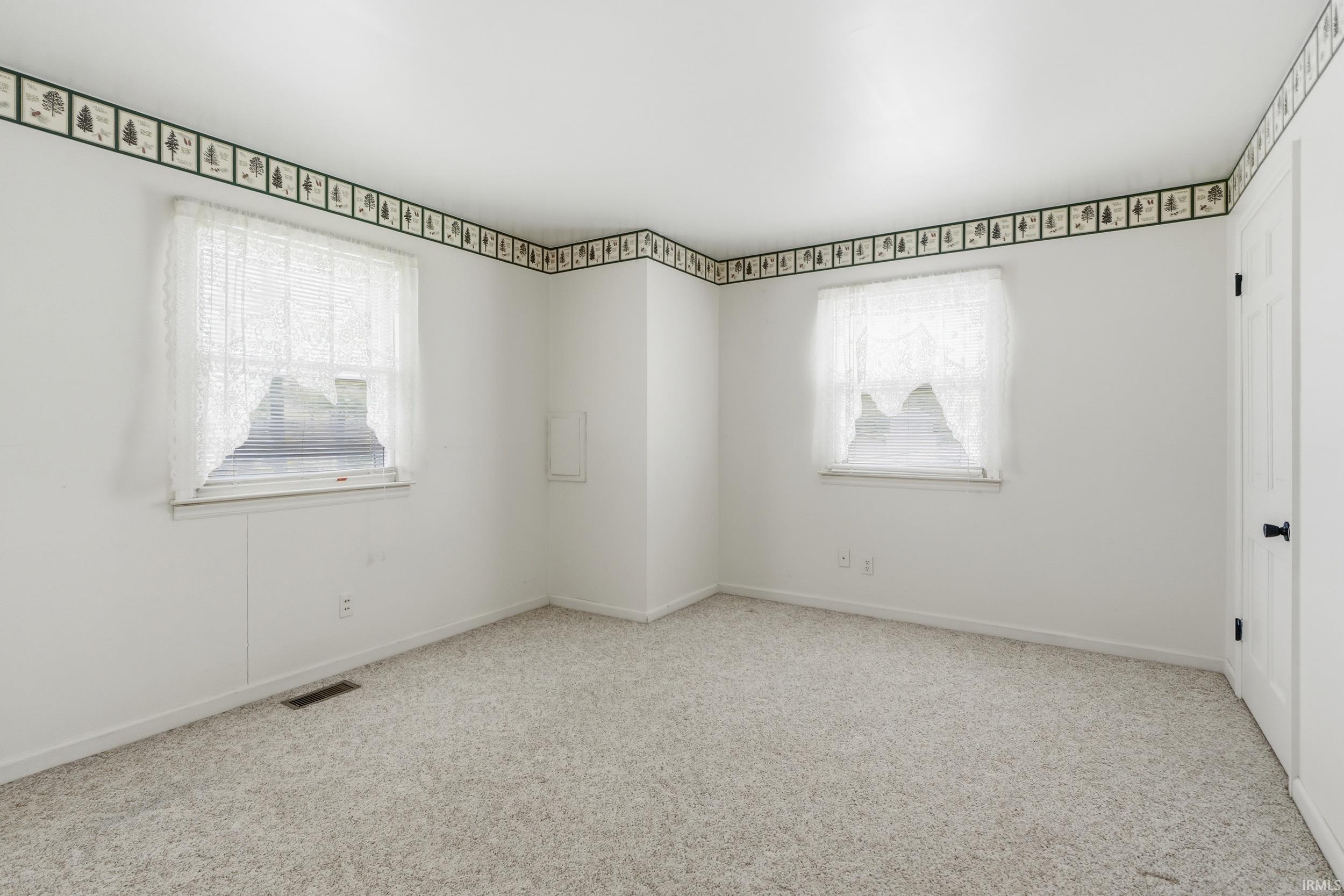 Bright room featuring light-toned carpeting and white walls
