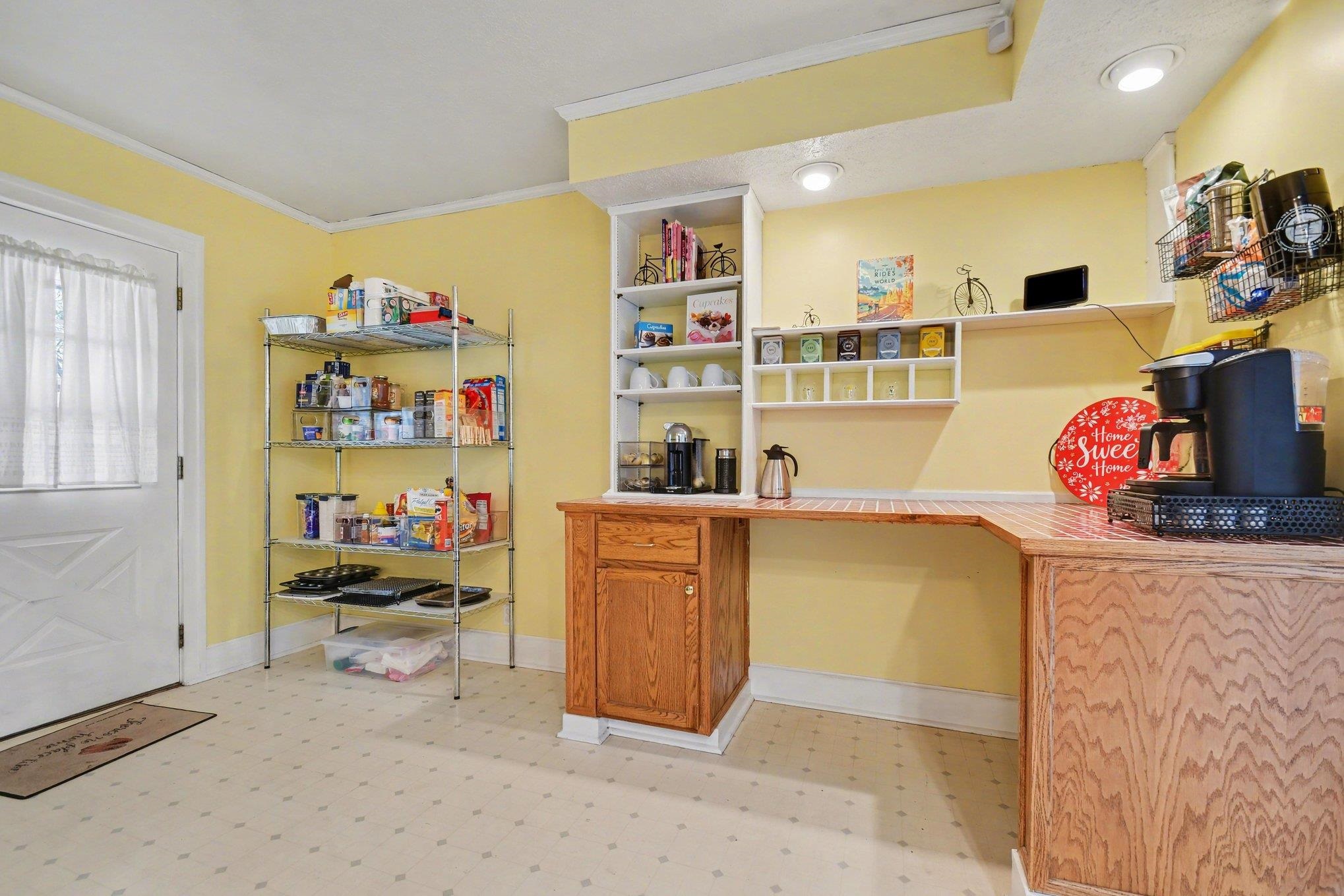 Functional beverage station featuring wood-finish cabinetry, a patterned countertop, and recessed lighting