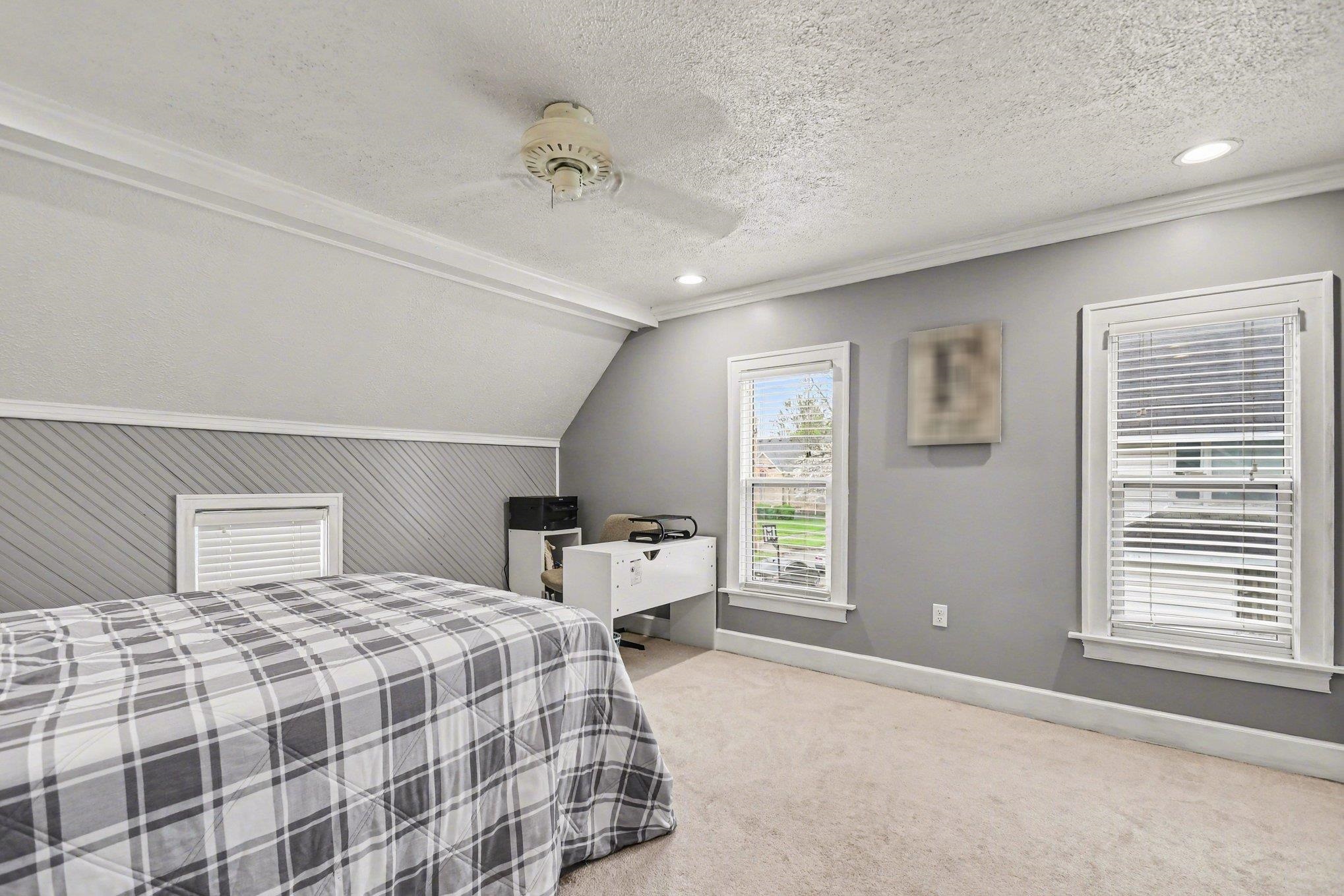 Carpeted room featuring dual windows with blinds, recessed lighting, crown molding, and a ceiling fan