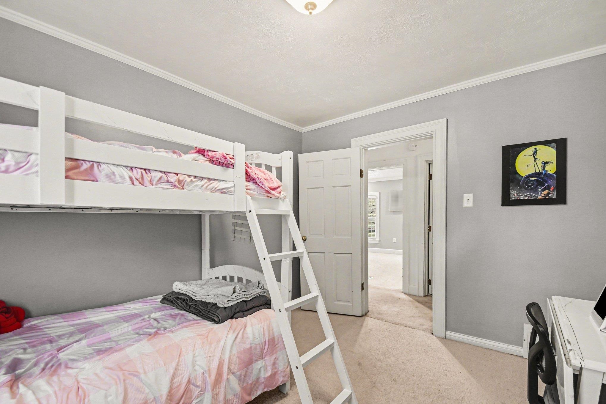 Carpeted room with light gray walls, white trim, and a white six-panel door